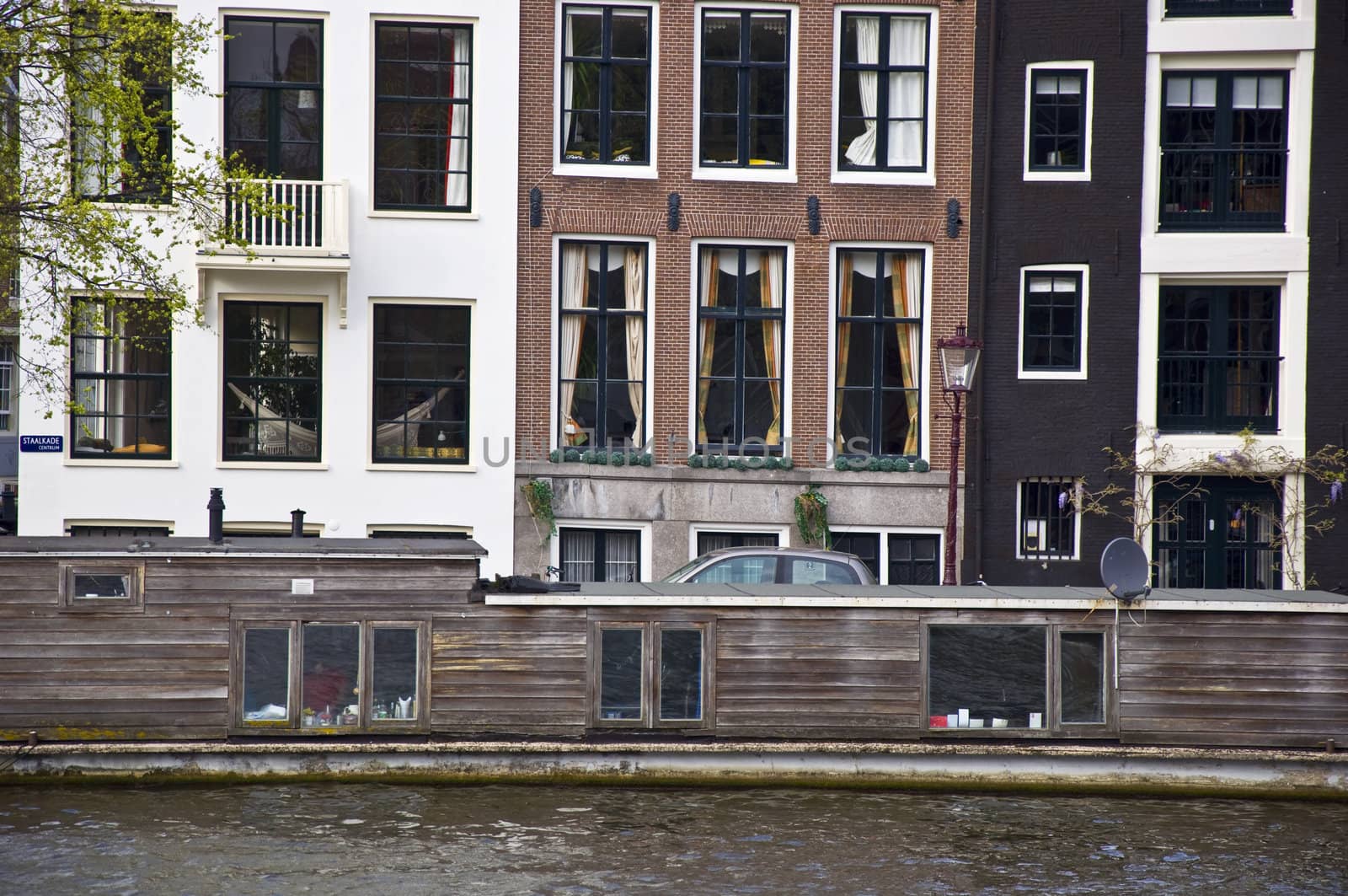 Dutch architecture. The barge is in the channel against the backdrop of the Amsterdam houses. Frontally. Fragment.