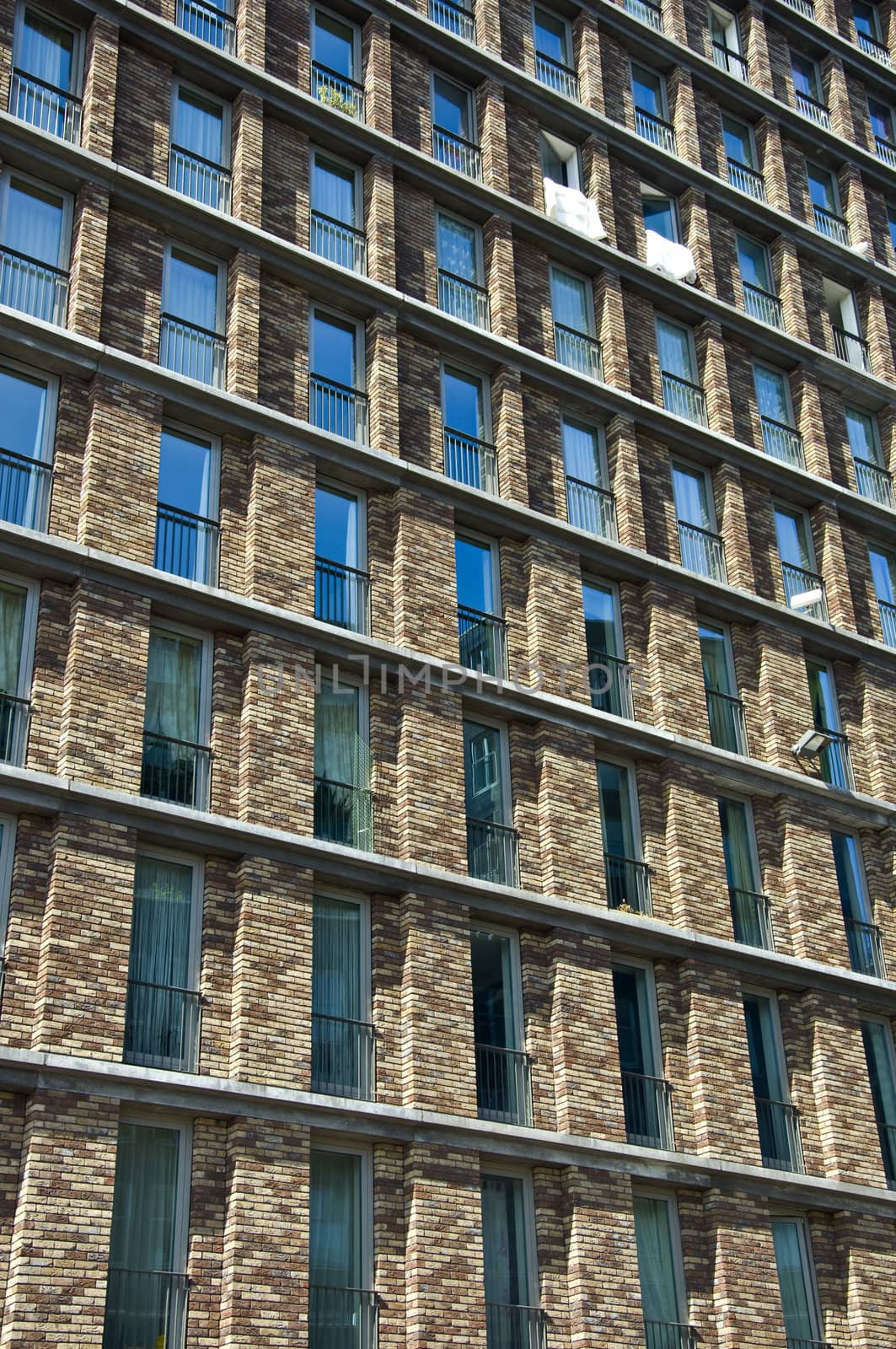 Fragment of the facade of the modern brick residential house with the same balcony. Detail.