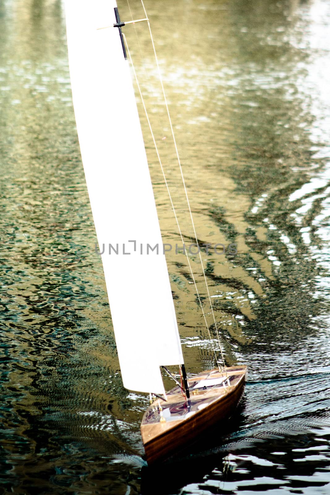 small boat with white sail reflection in the water