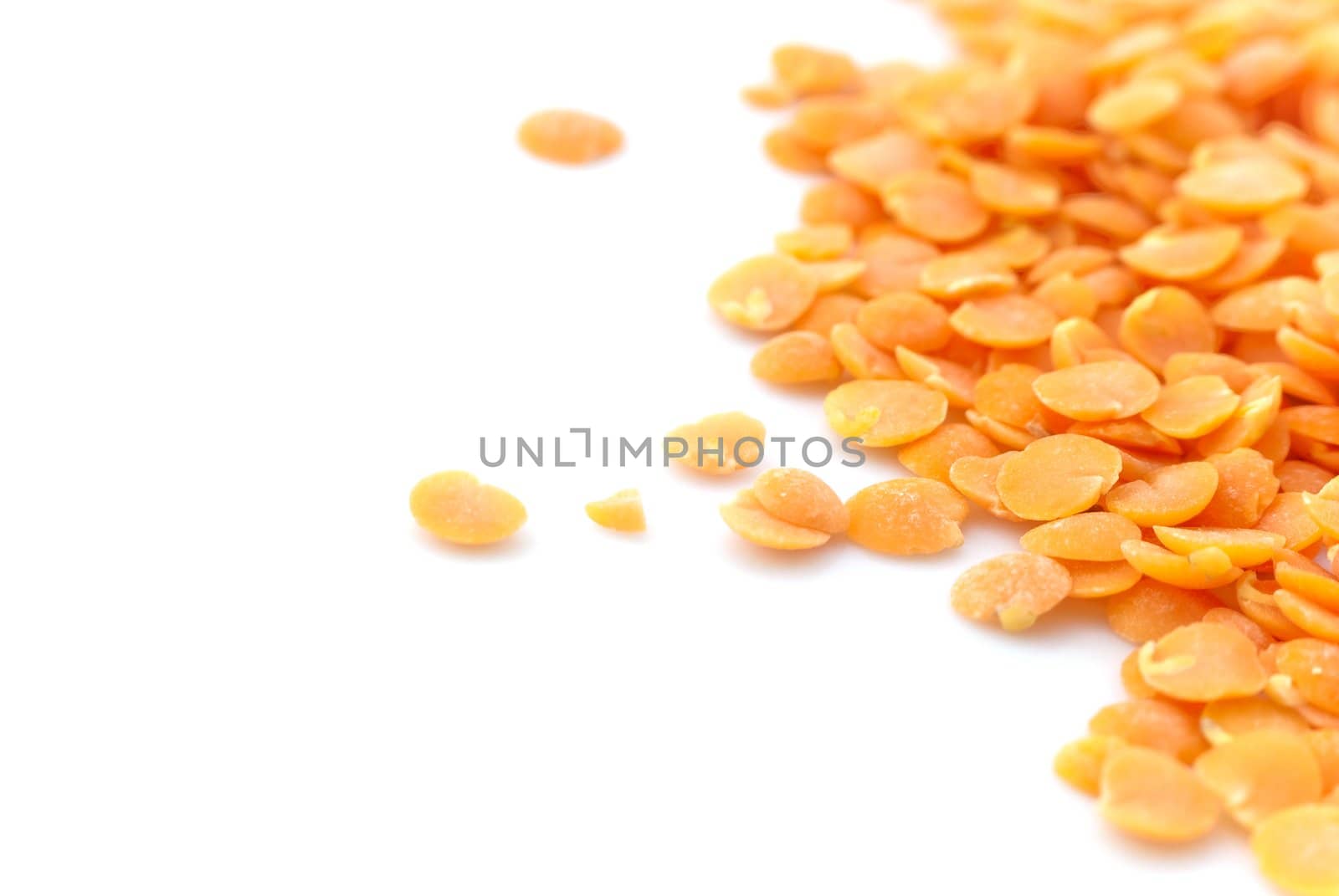 Macro (close-up) of red (orange) lentils isolated against white surface.