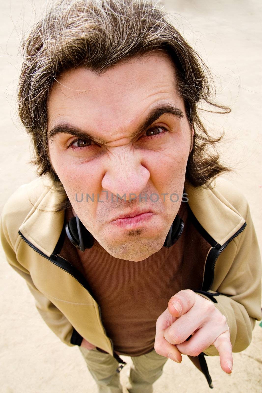 Funny man shot from above with wide-angle lens looks angrily and sticks two fingers into camera