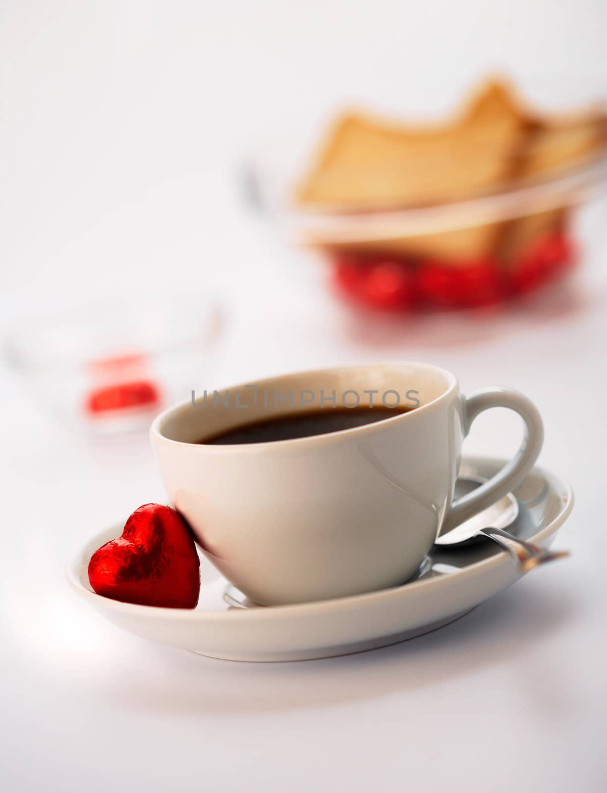 White cup with coffee and one chocolate