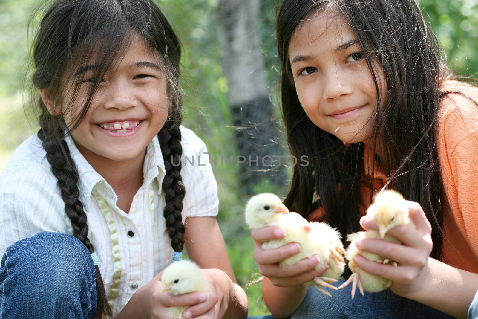 Two happy girls holding their pet chicks