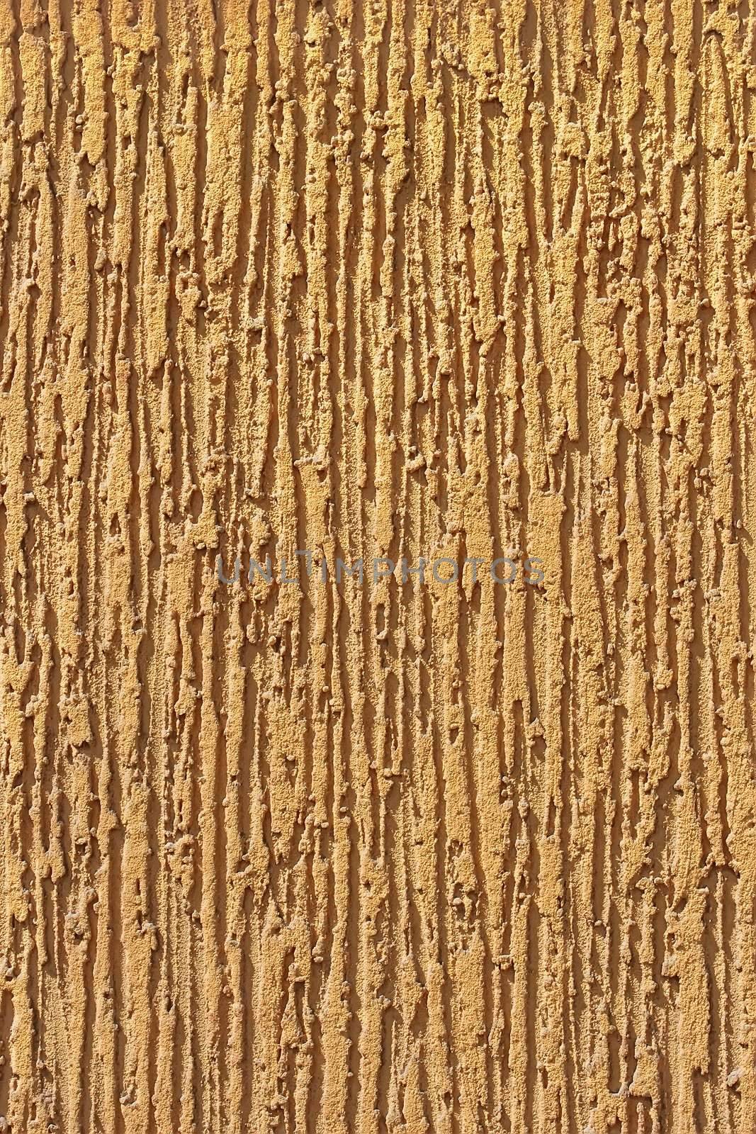 Fragment of light brown ornamental wall stucco covering 