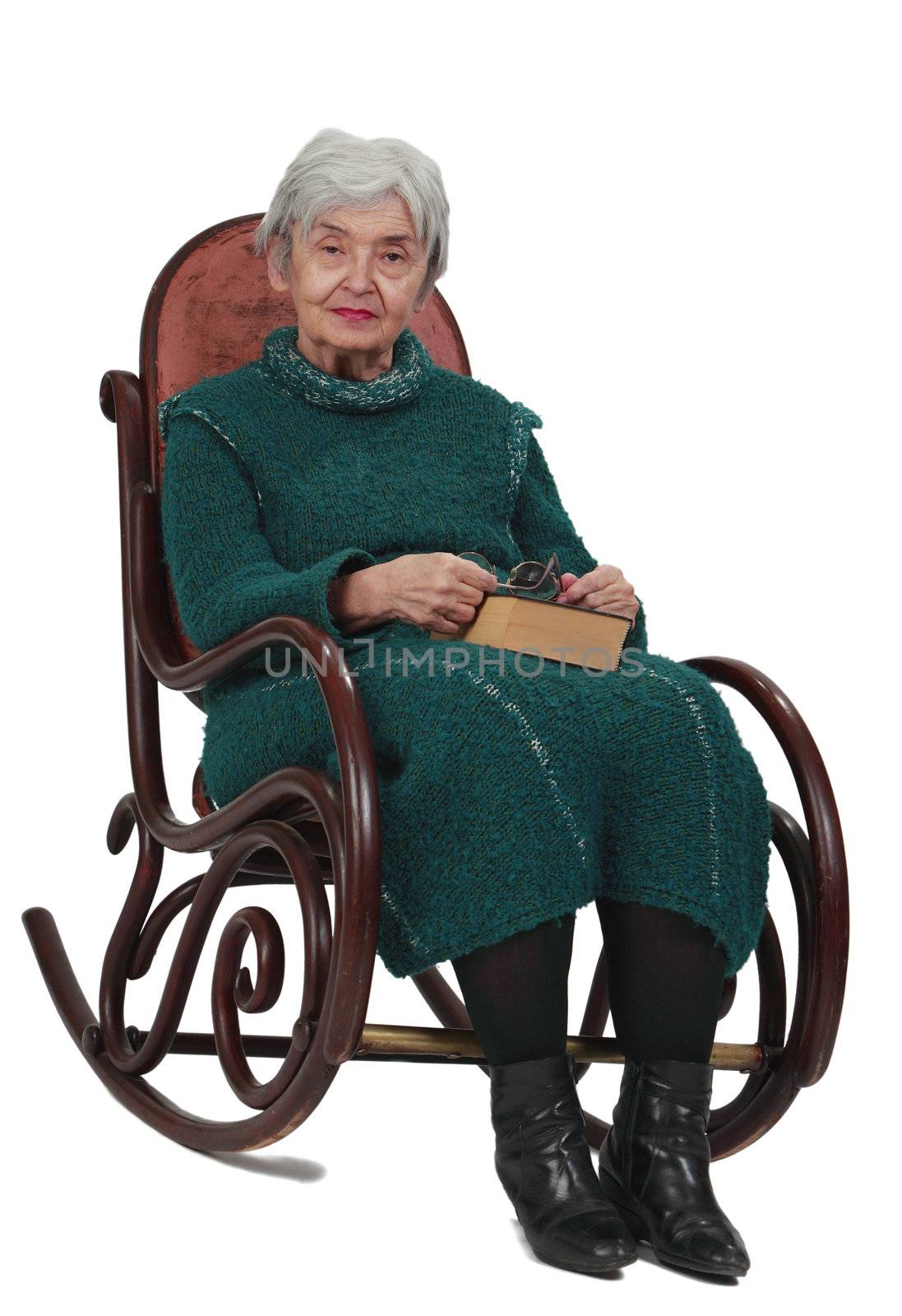 Image of an old woman sitting on a rocker with a closed book in her lap.