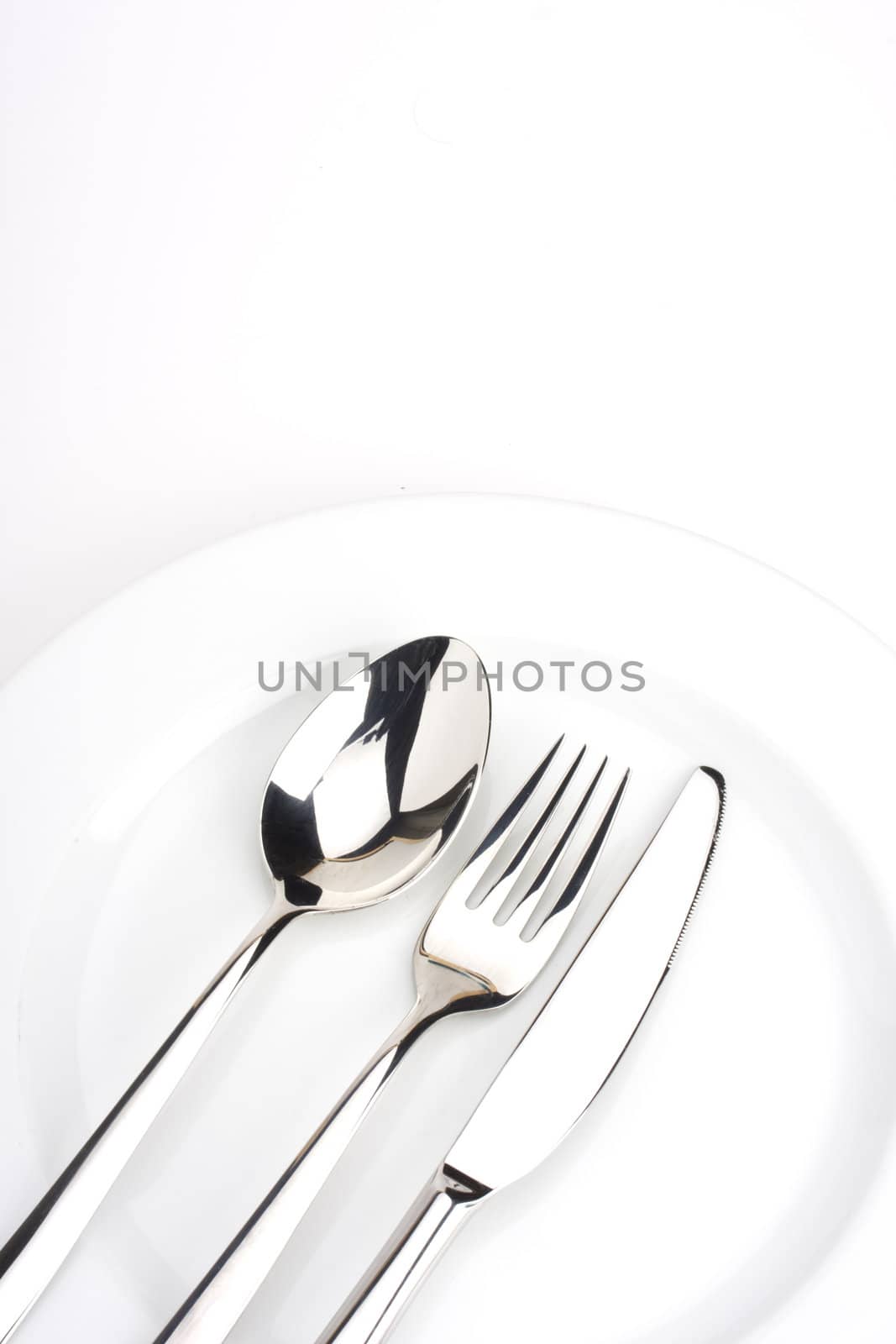 fork, knife, spoon and a white plate by bernjuer