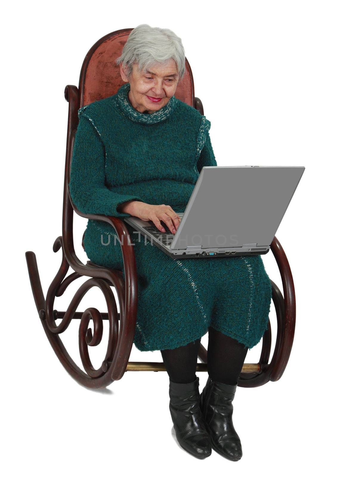 Image of a senior woman using a laptop while sitting in a rocker.