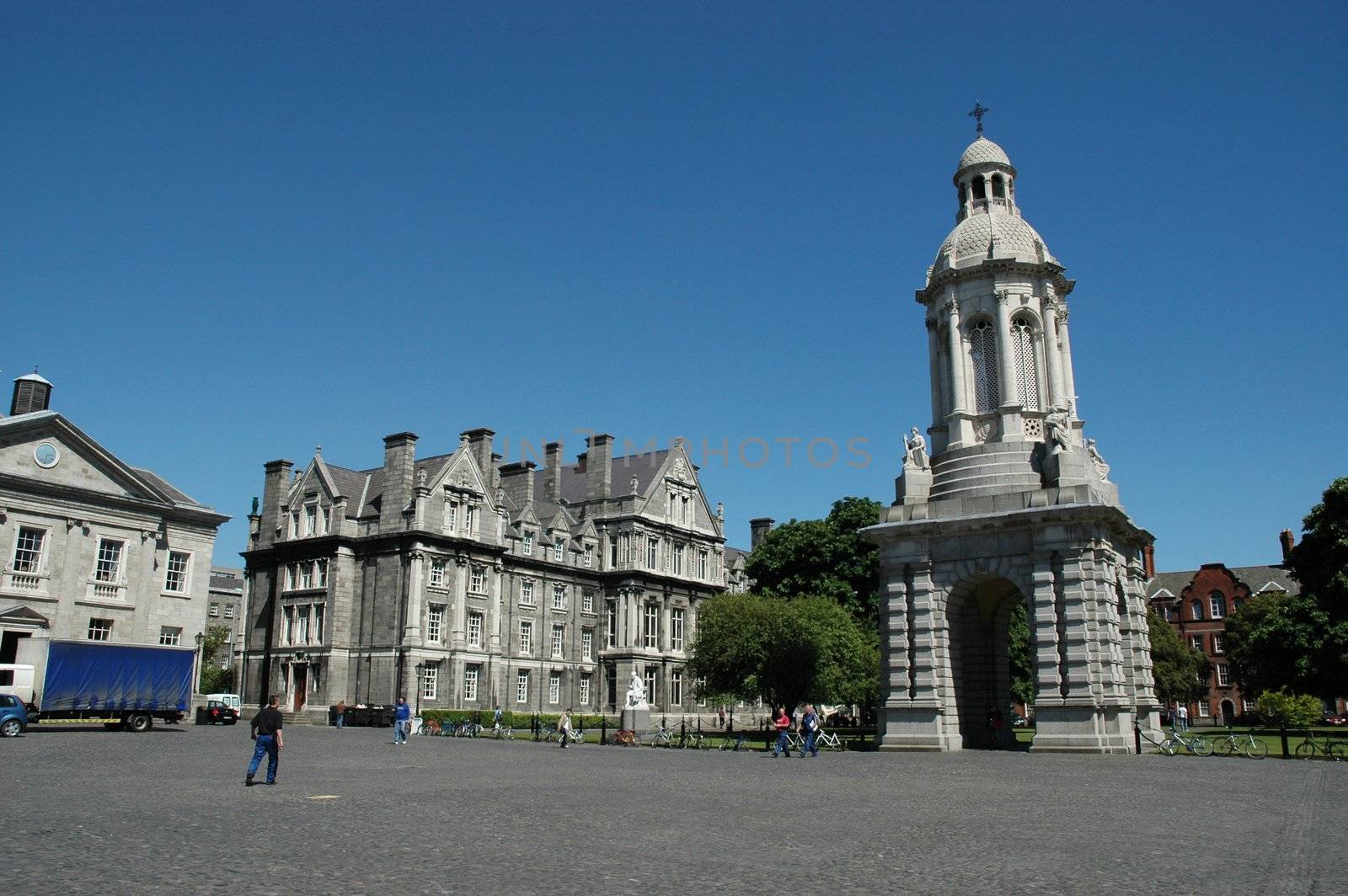 Wide angle shot of the Quad in Trinity College Dublin with the beautiful Bell tower to the right against a bright blue sky