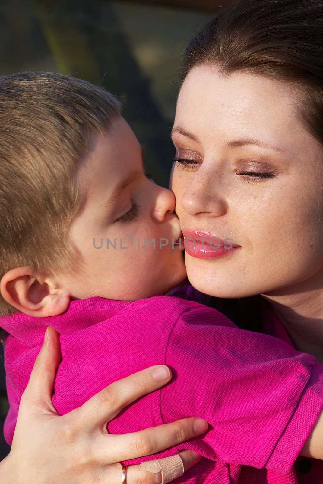 Closeup portrait of a preschool boy kissing his mother