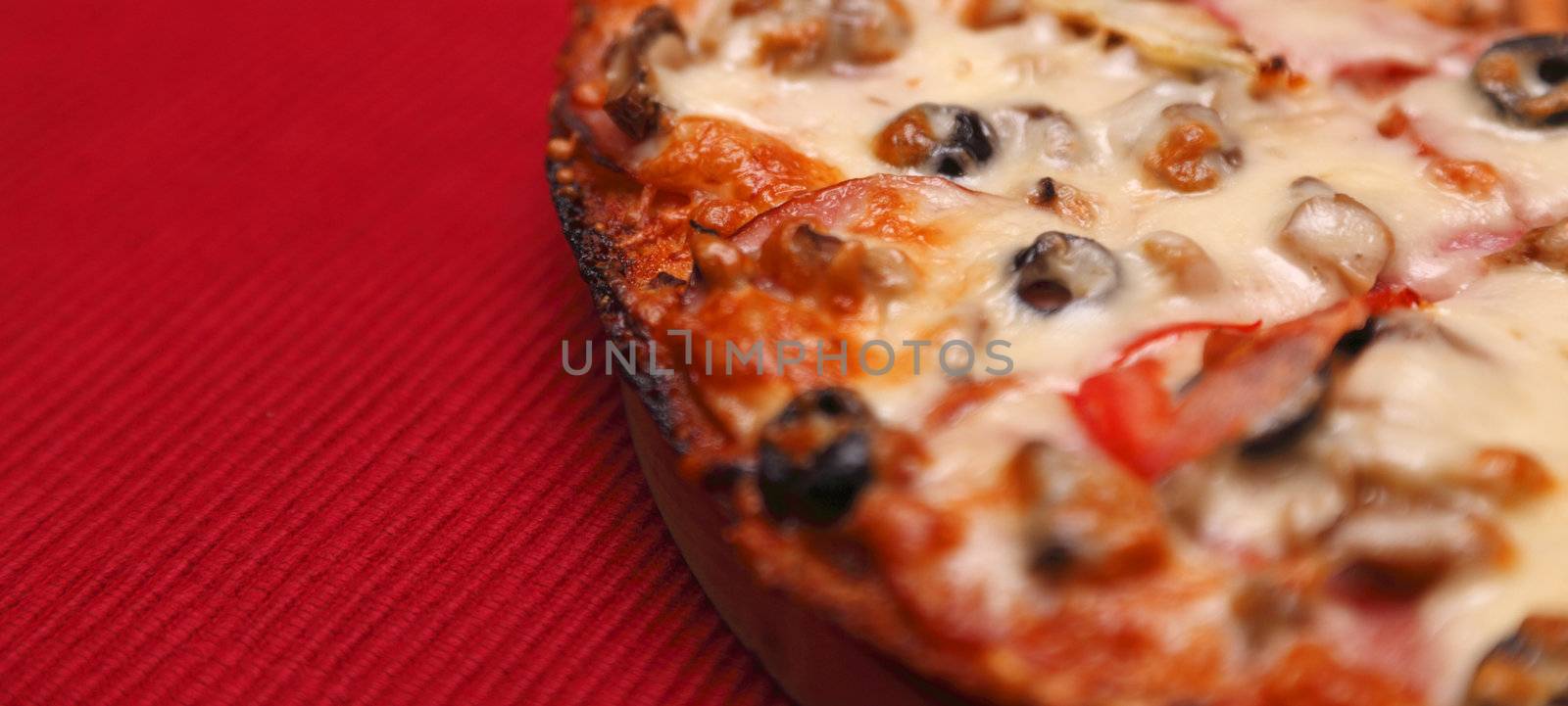 Close-up image of a tasty pizza on a red table cloth.