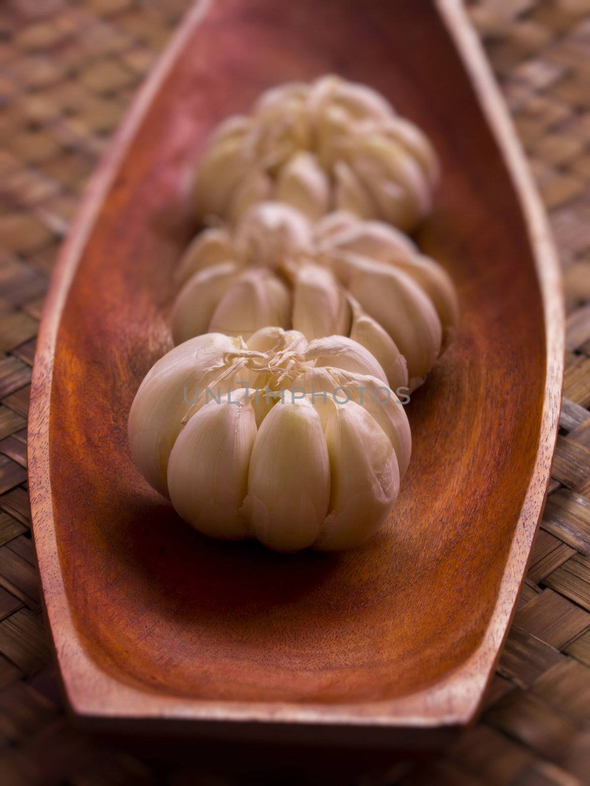 close up of garlic in wooden bowl