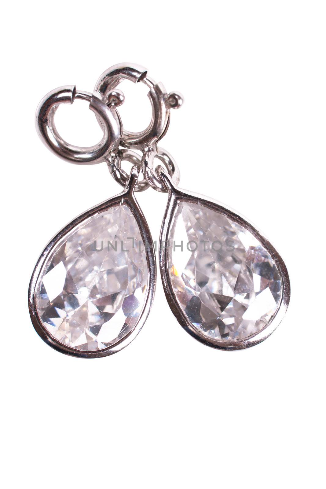 Closeup view of two silver earrings over white background