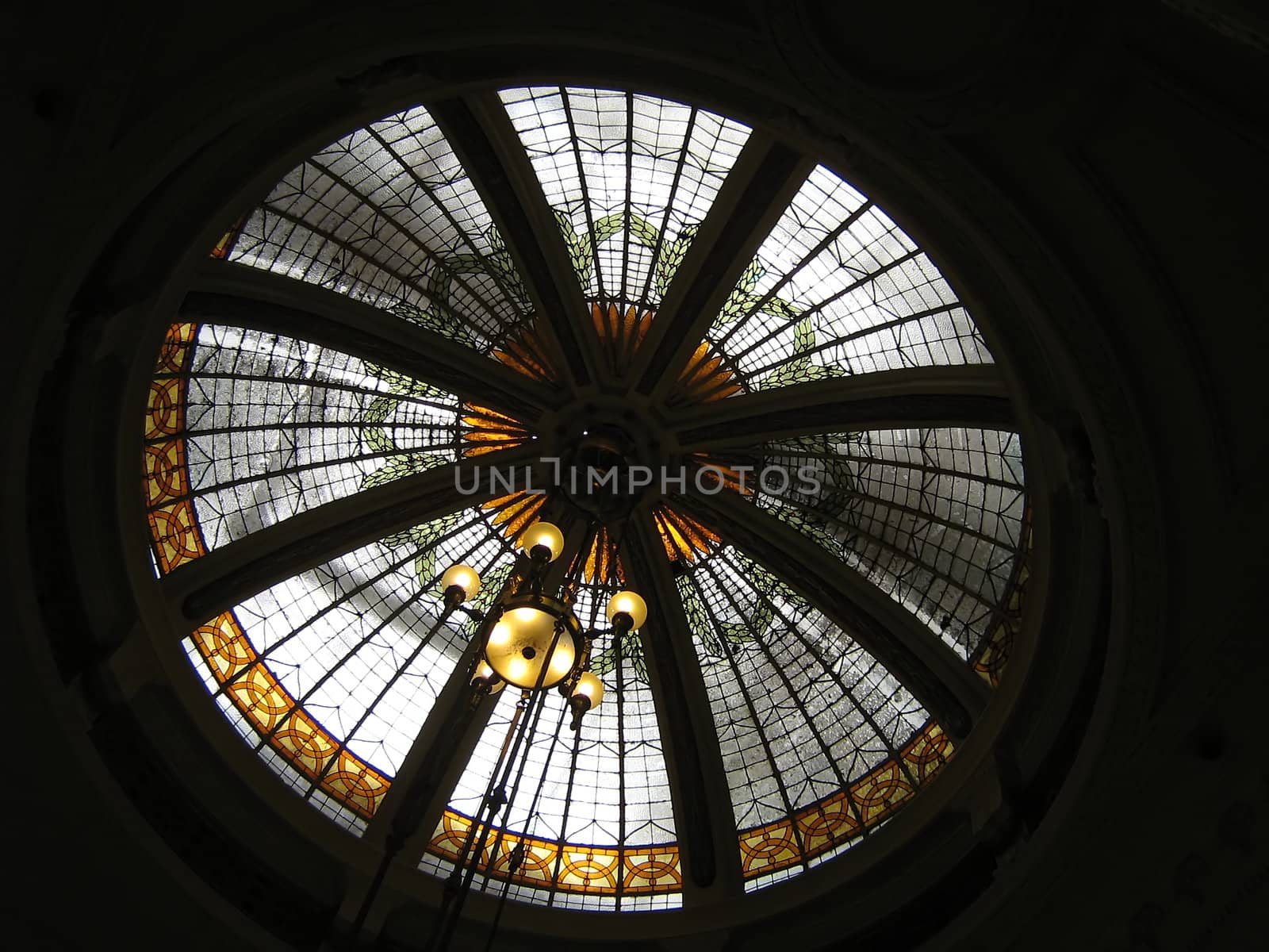 A photograph of a stained glass window inside the dome of a church.
