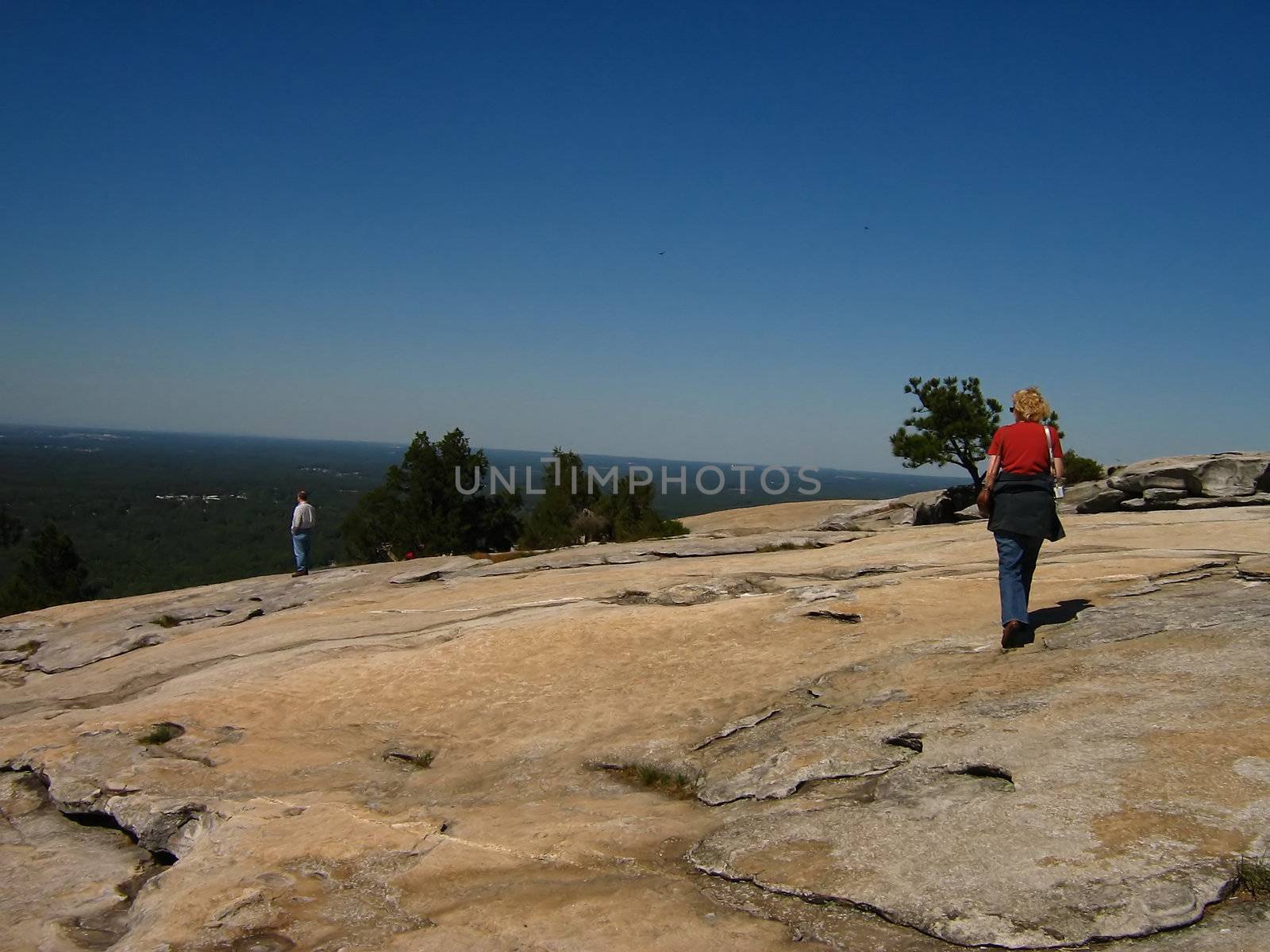 A photograph of a man and woman on top of Stone Mountain. Stone Mountain which is located near the city of Atlanta
in the state of Georgia in the United States, features the largest bas relief sculpture in the world. This sculpture shows Jefferson Davis (president of the U.S. Confederacy circa 1861 - 1865) and Confederate Generals Robert E. Lee 
and Thomas Jonathan "Stonewall" Jackson.
