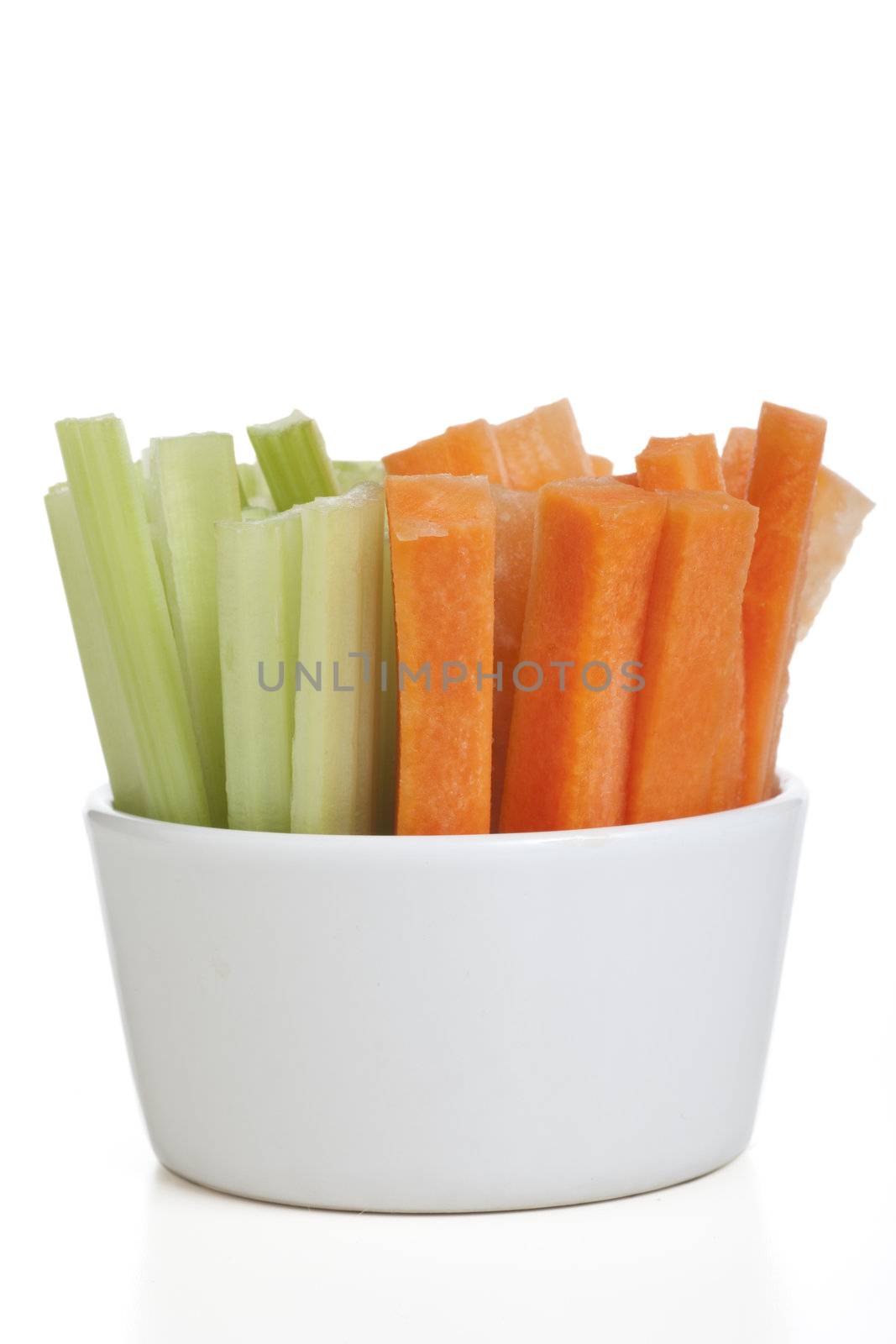 Bowl of carrot and celery sticks isolated on a white background.