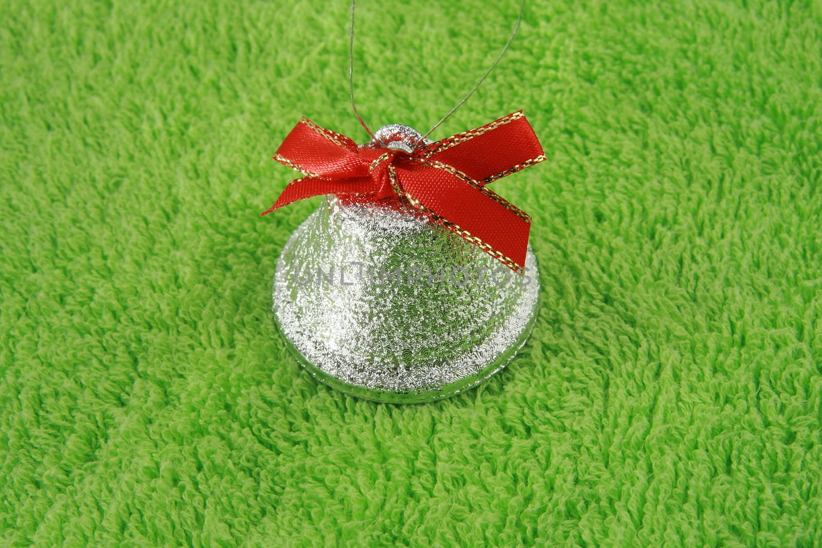 silver bell with red ribbon