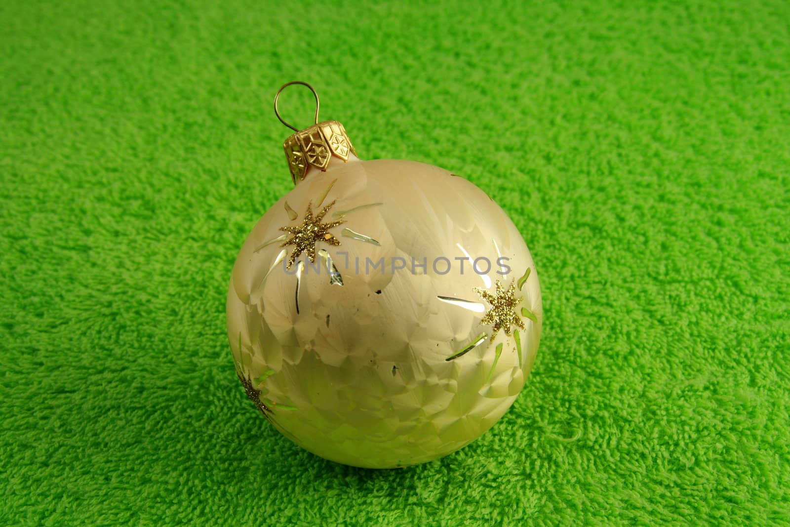 golden ball with a stars on soft green surface
