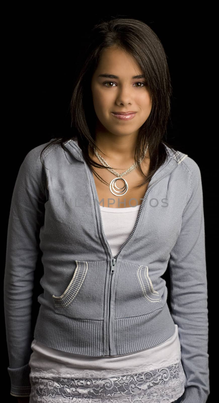 Teen girl standing against a black background