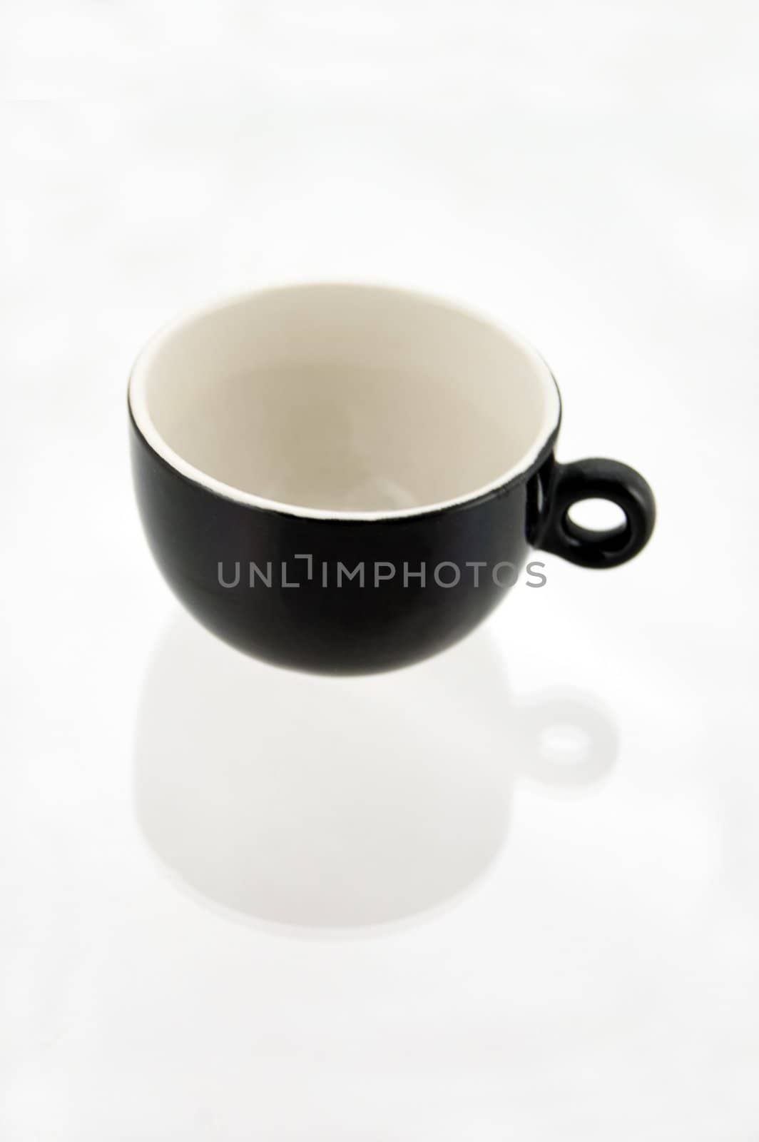 essential photo of an empty black and white cup for coffee with shadow reflection
