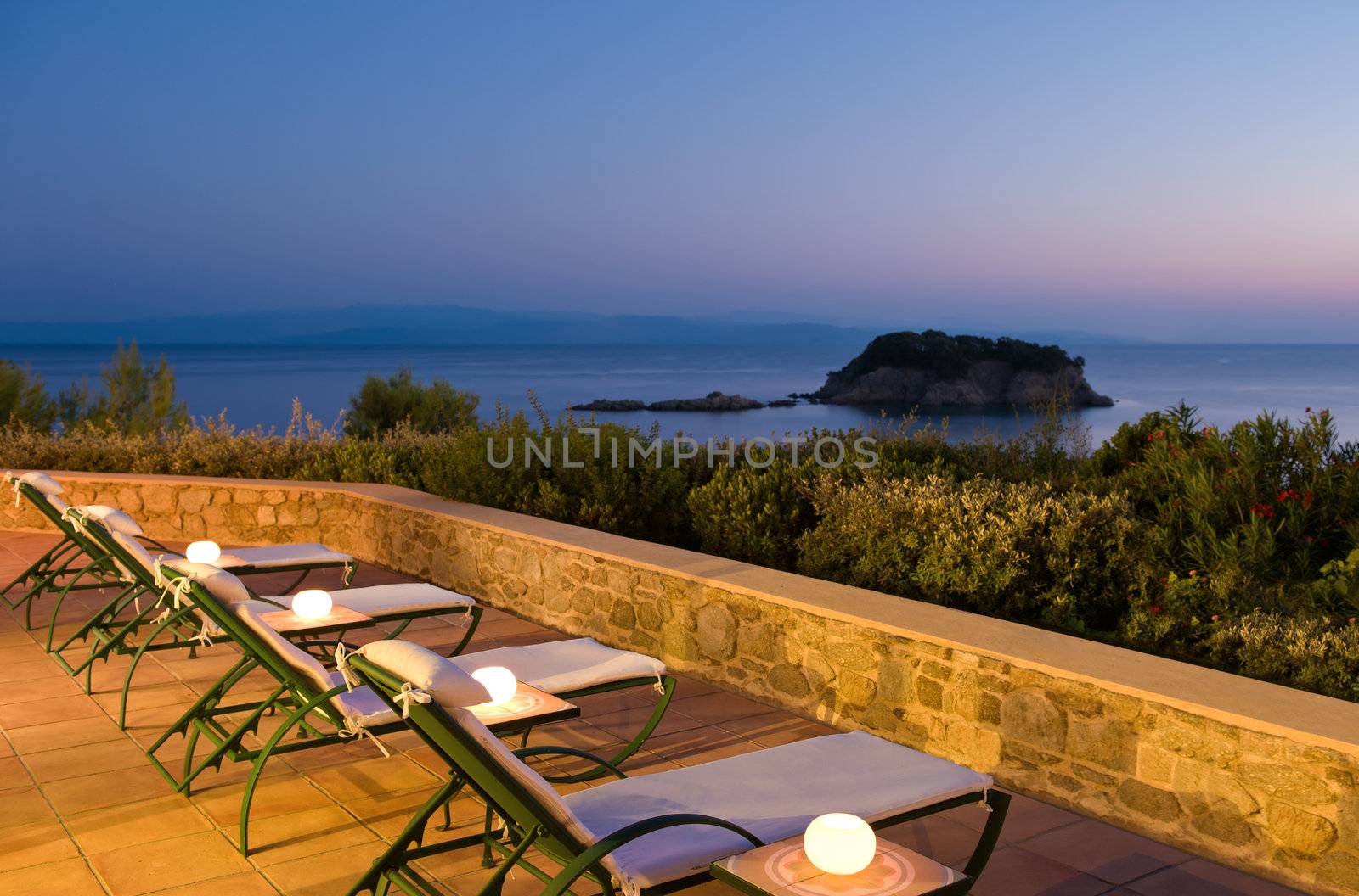 Evening picture of deckchairs on Greek verandah for people to experience the sea view 
