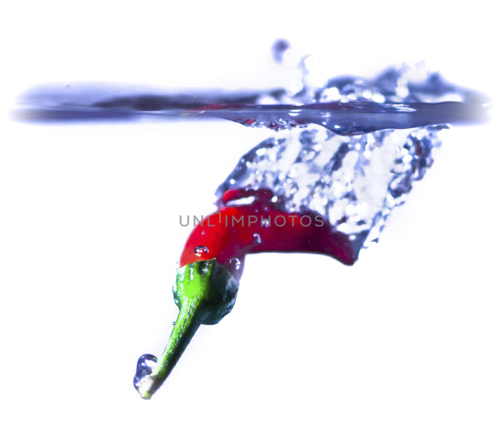 A red chilli splashing into water.