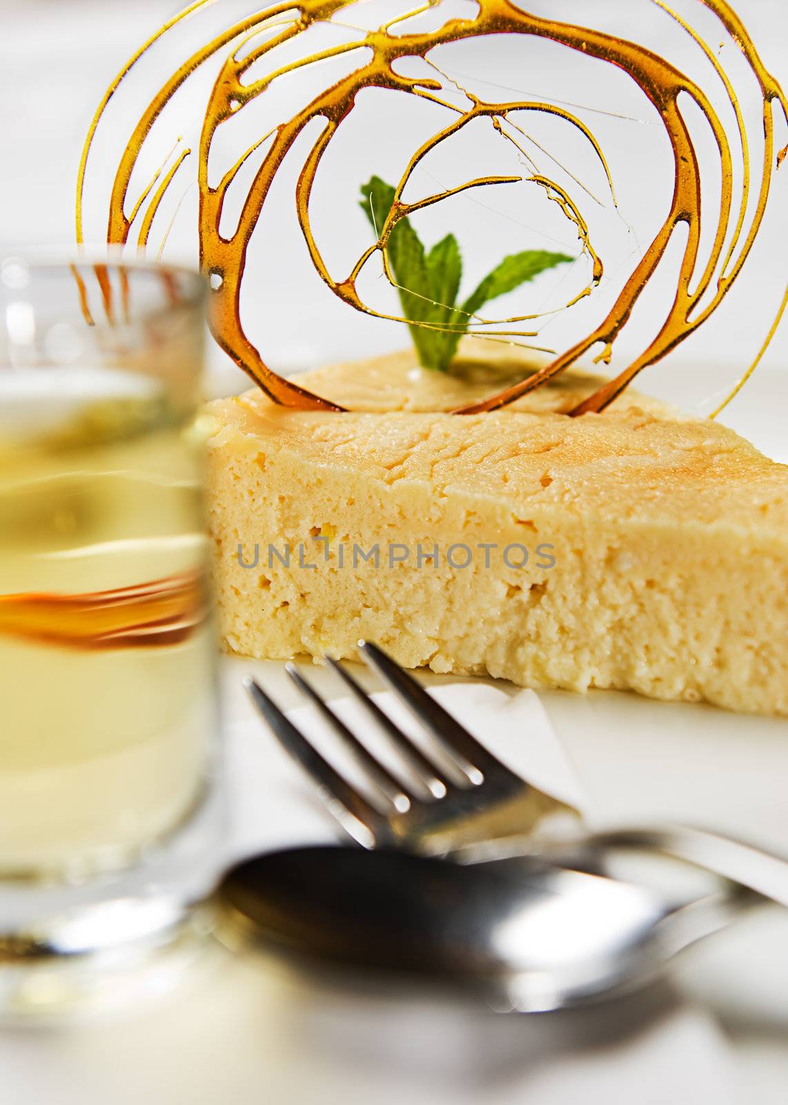 A delicious slice of cheesecake served with toffee, syrup and a dessert shot.
