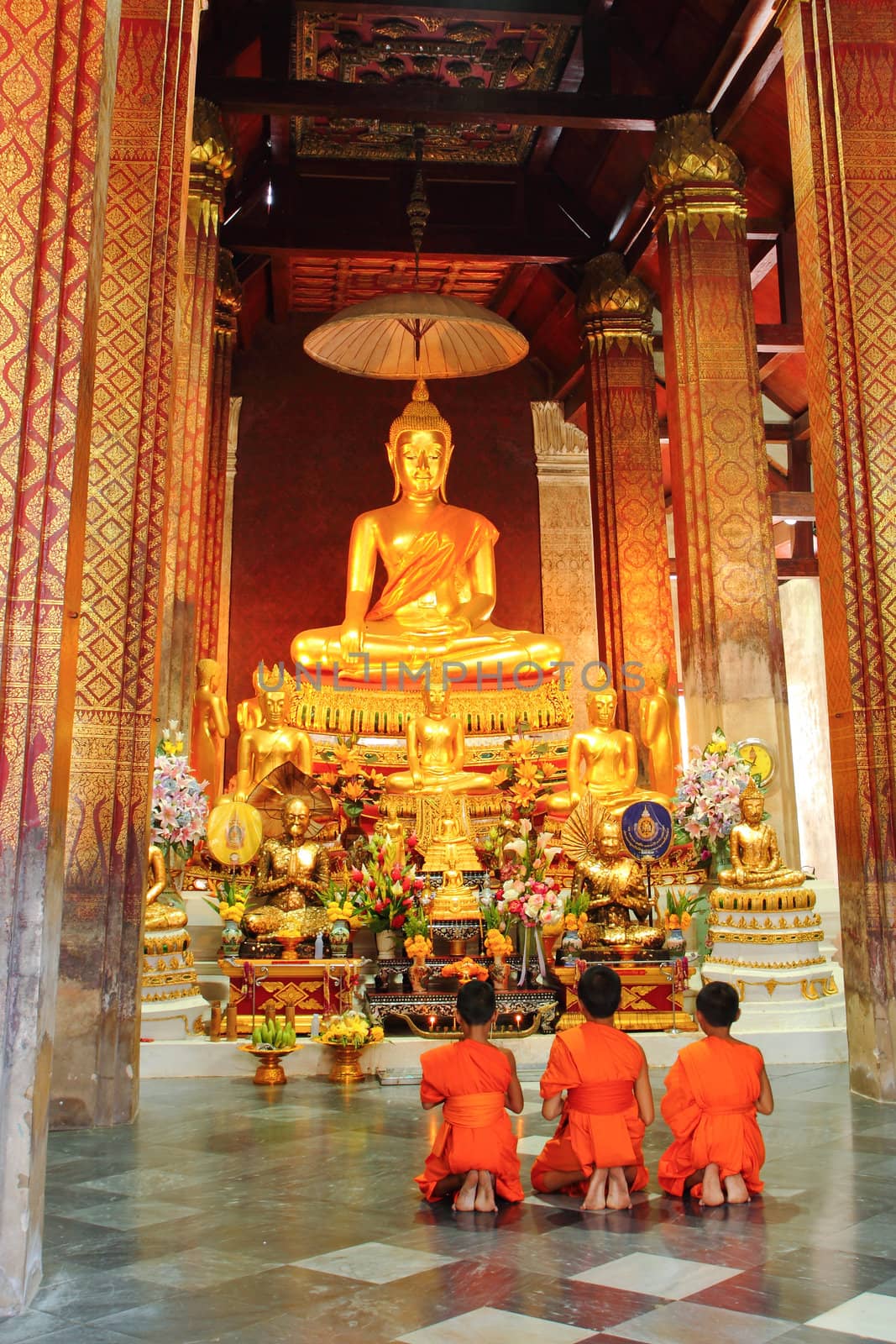 Young monks praying at church in Thailand