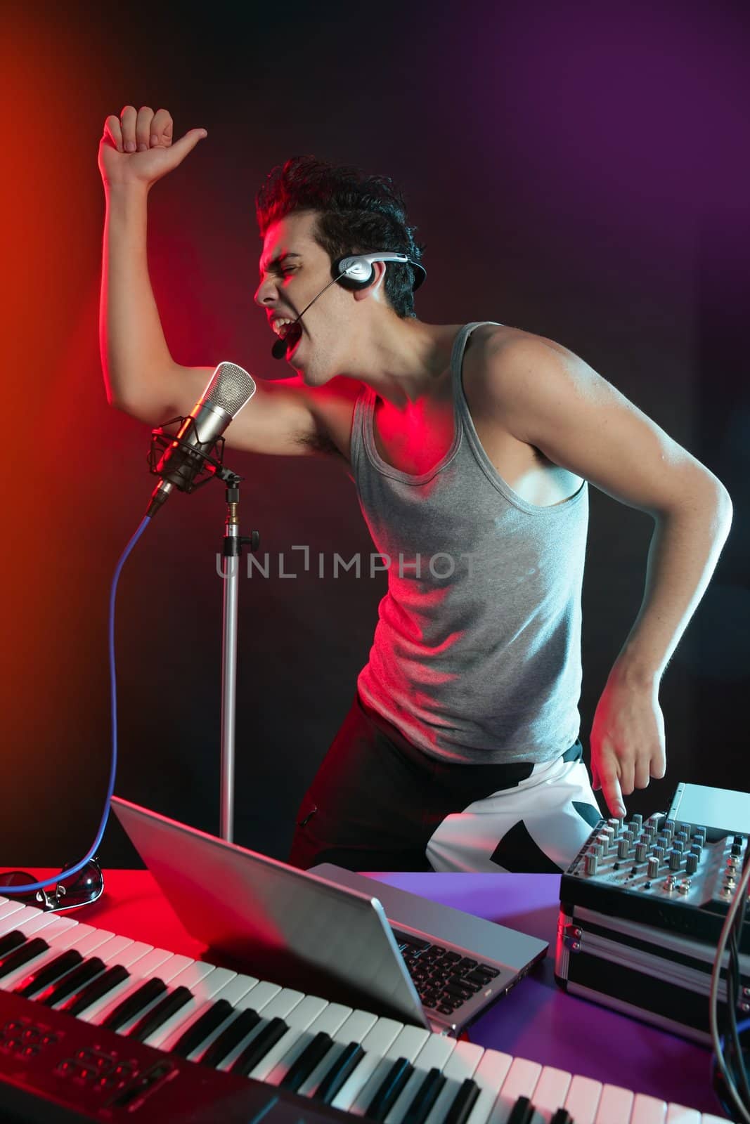 Dj with colorful light and music mixing equipment by lunamarina
