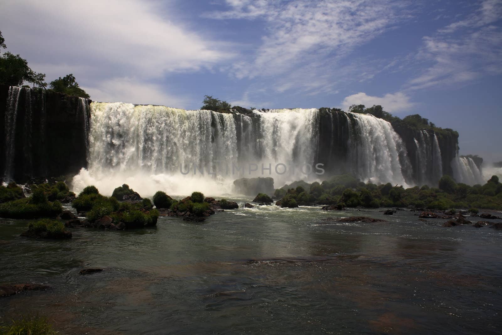 The Iguassu (or Iguazu) Falls is one of the largest masses of fresh water on the planet and divides, in South America, Brazil, Paraguay and Argentina. The waterfall system consists of 275 falls along 2.7 kilometres (1.67 miles) of the Iguazu River. Some of the individual falls are up to 82 metres (269 feet) in height, though the majority are about 64 metres (210 feet).