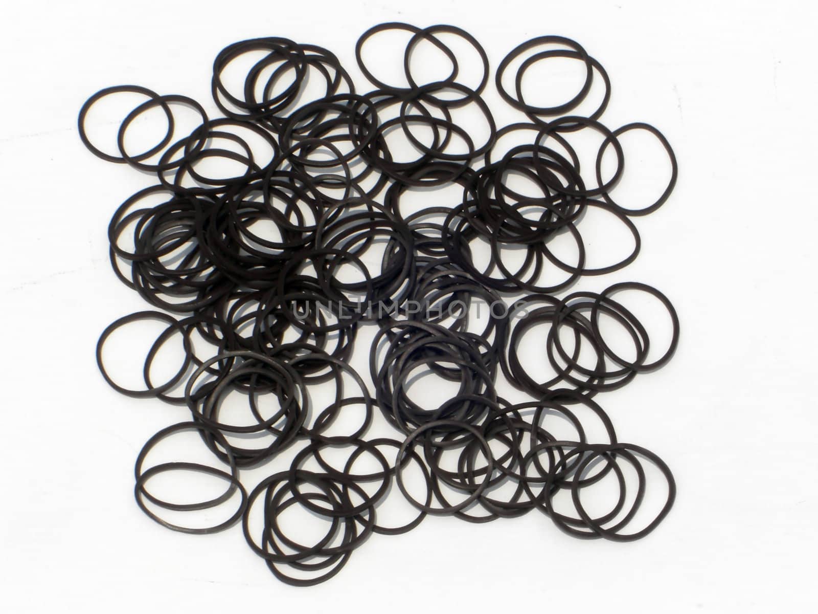 A pile of brown rubber bands are scattered in a neat pile.