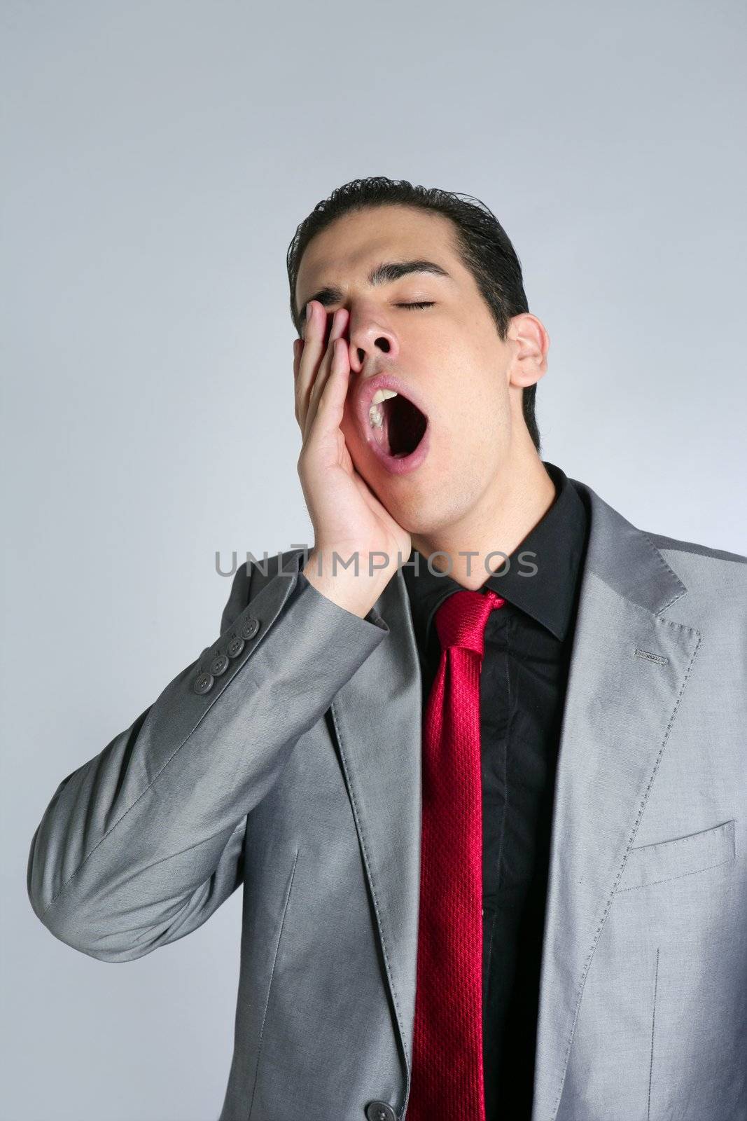 Businessman yawn boring on gray background with suit and red tie