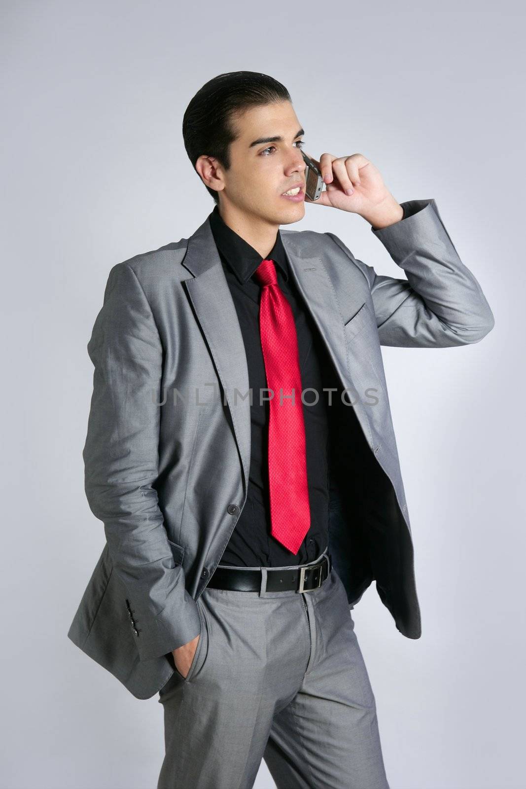 Businessman with gray suit talking cellular phone with suit and red tie