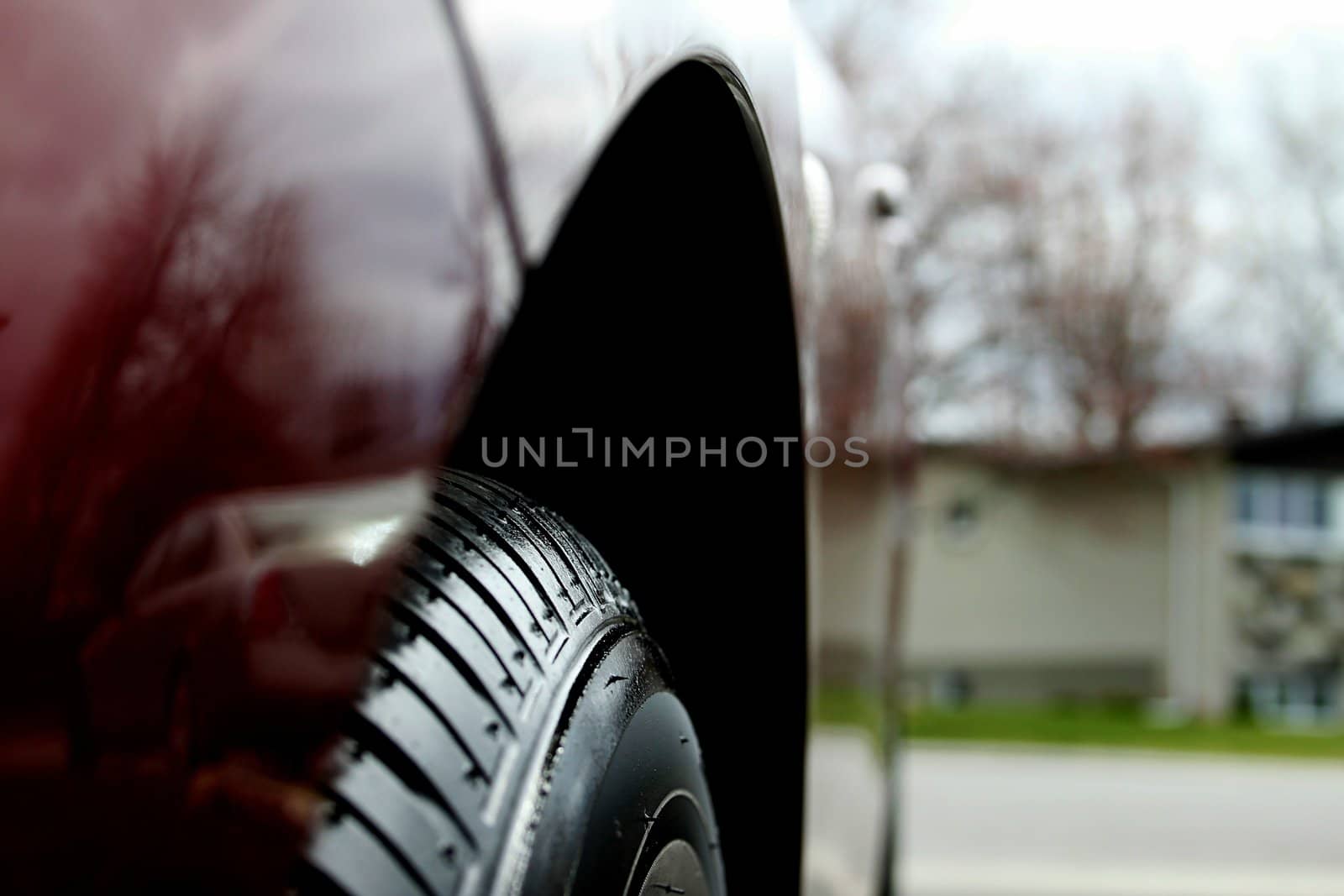 A close up look of the front wheel of red car