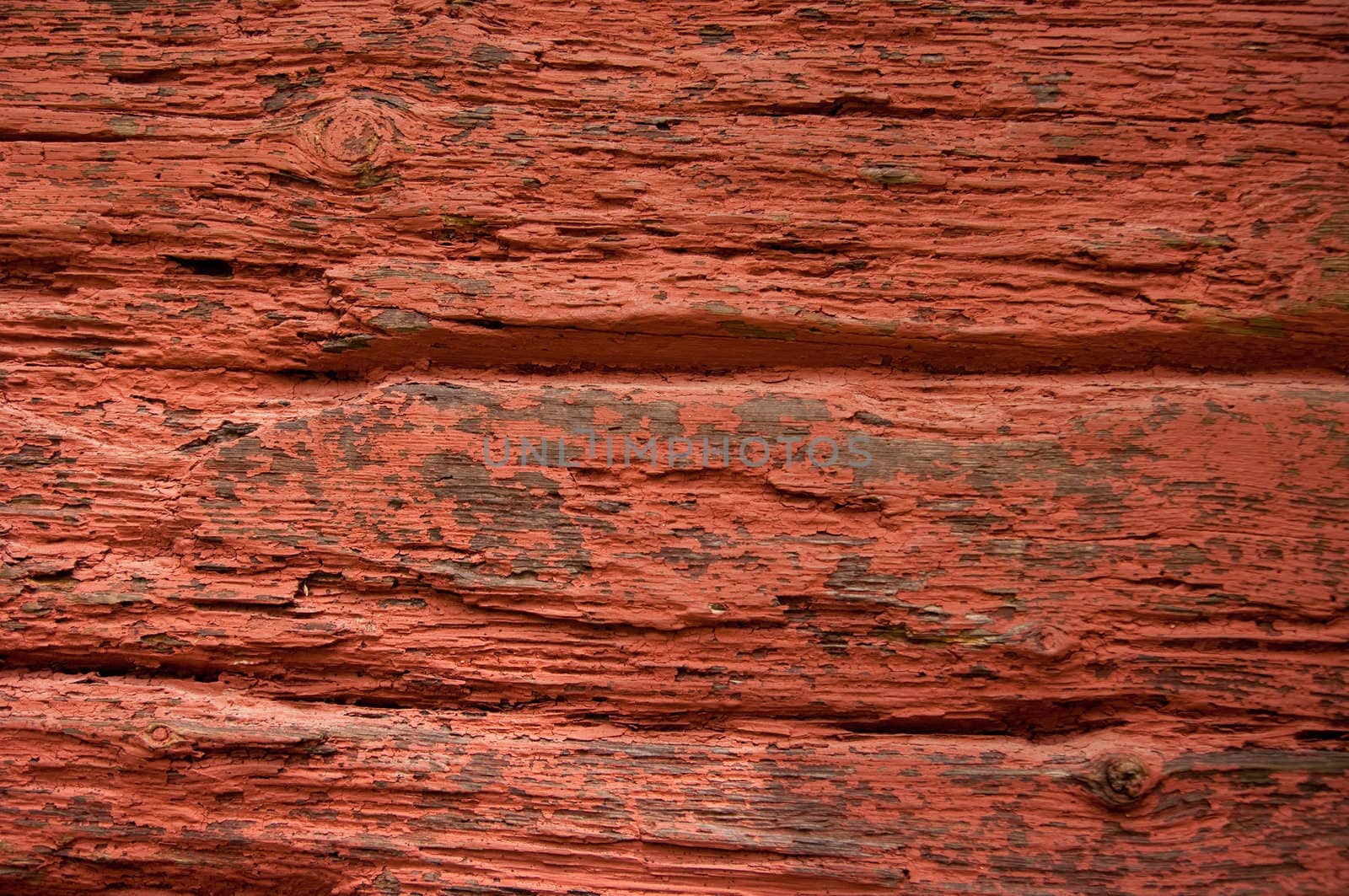 Old red paint falling of a wooden wall.