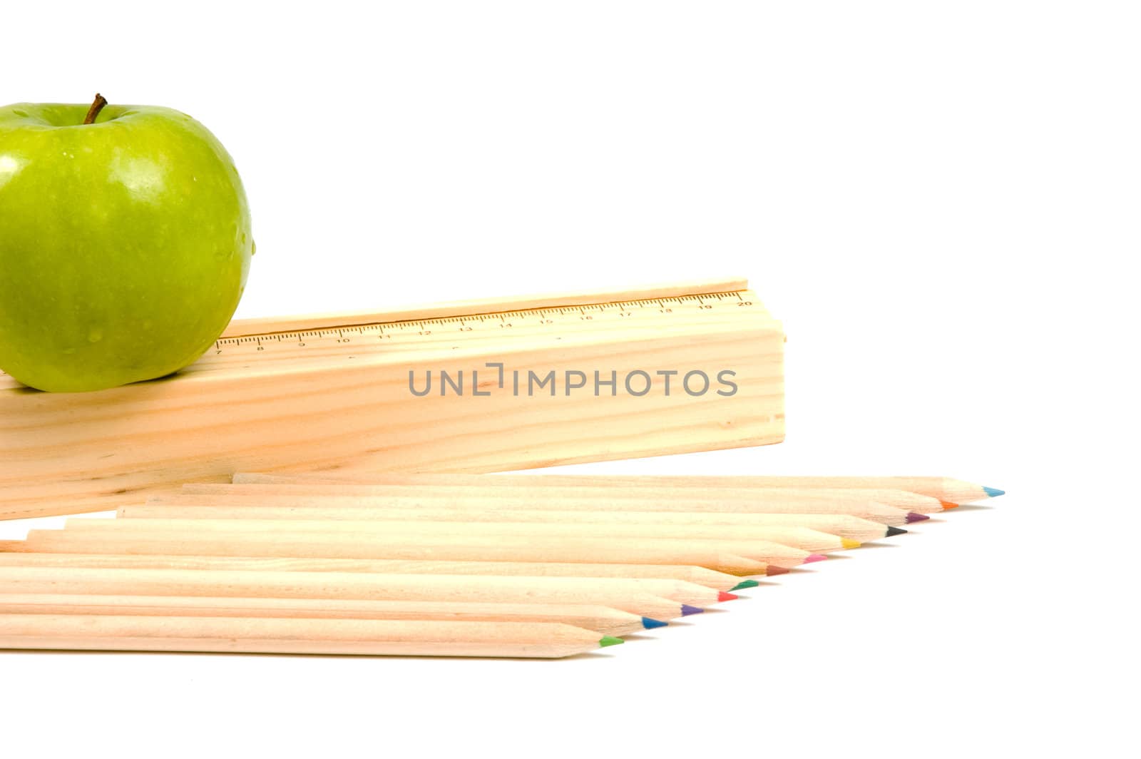 wooden school pencils and holder with rule and apple on white