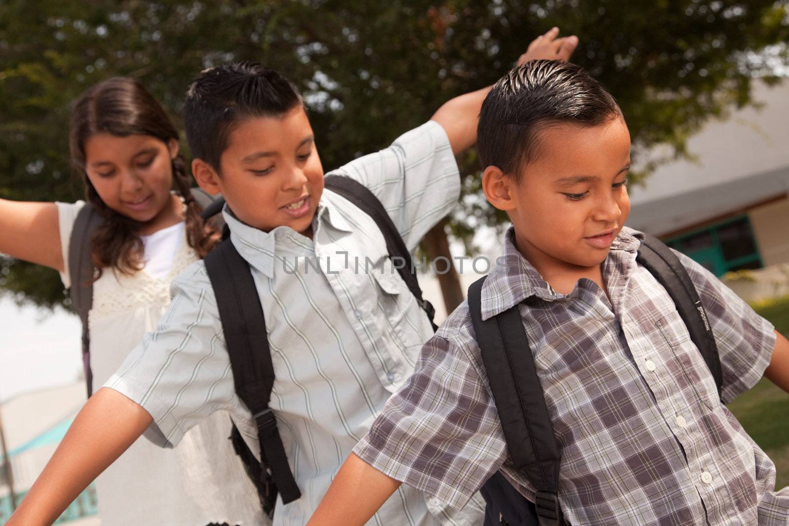 Cute Brothers and Sister with Backpacks Having Fun Walking to School.