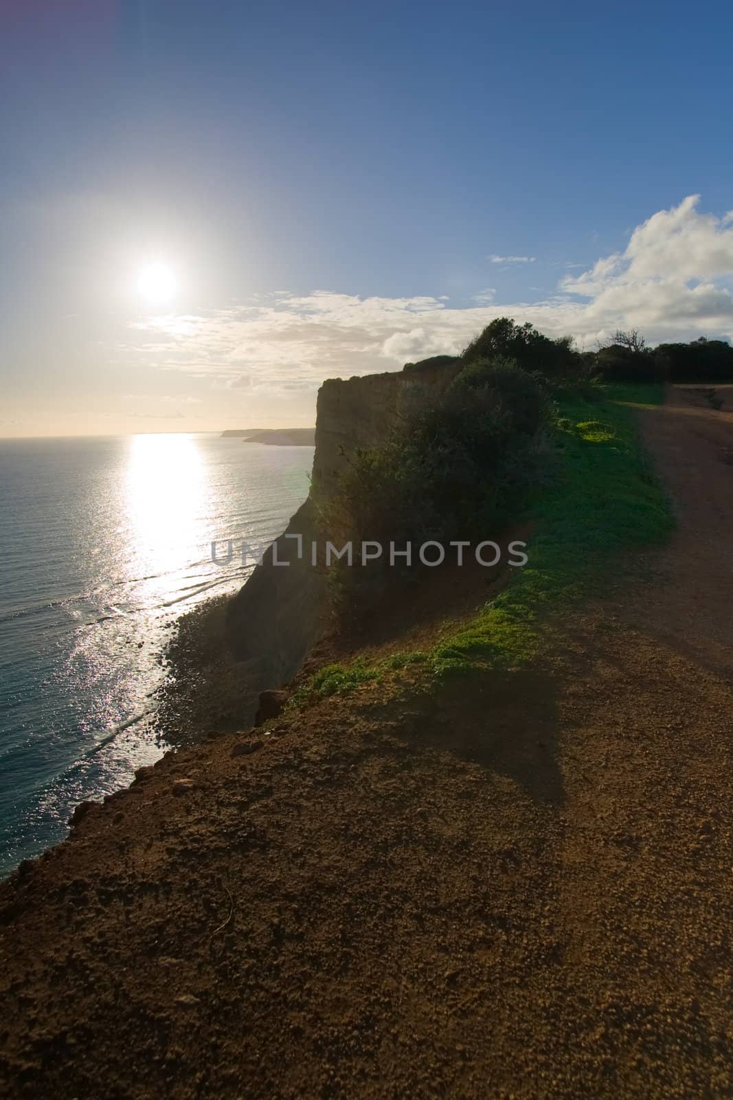 The cliffs of Lagos, Portugal, as the sun sets, shot into the sun.