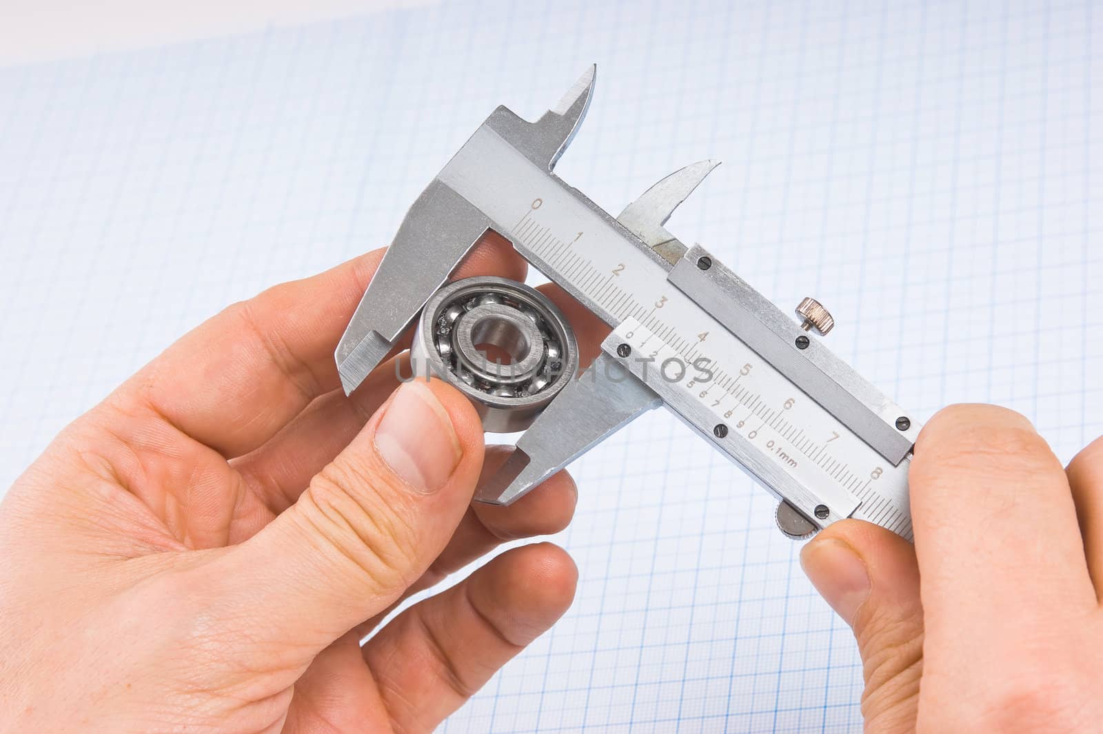 calipers, bearing and square on the background of graph paper