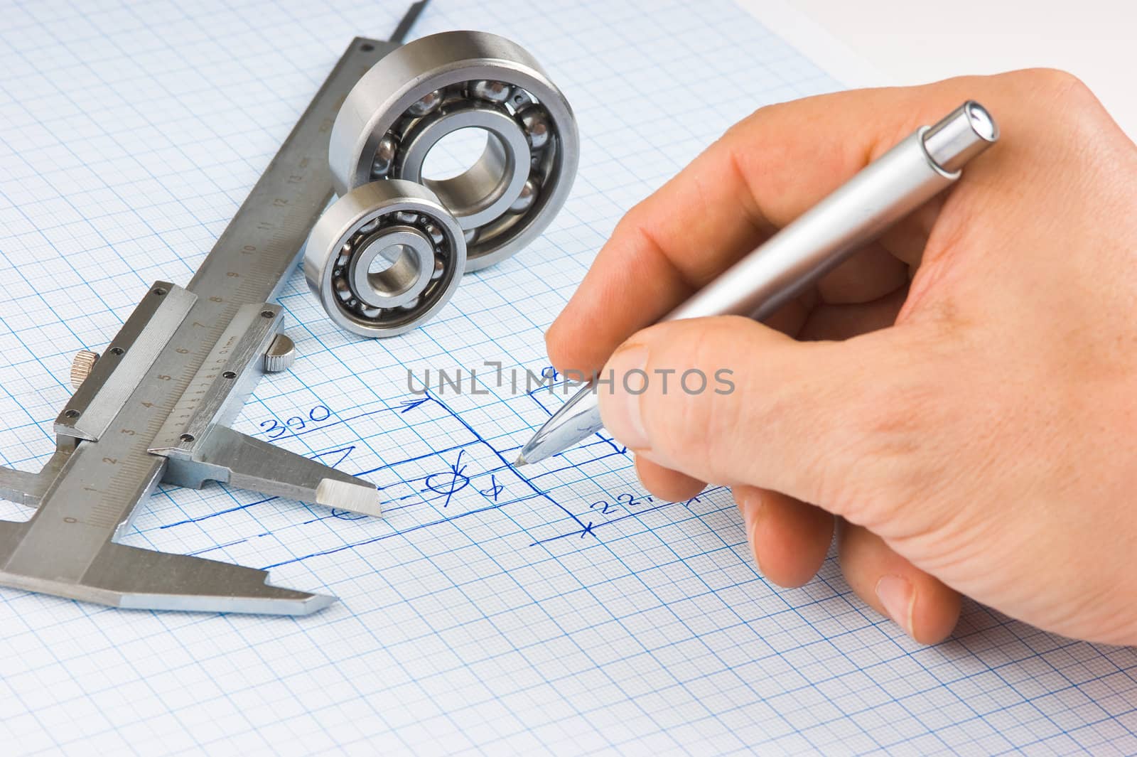 calipers, bearing and square on the background of graph paper