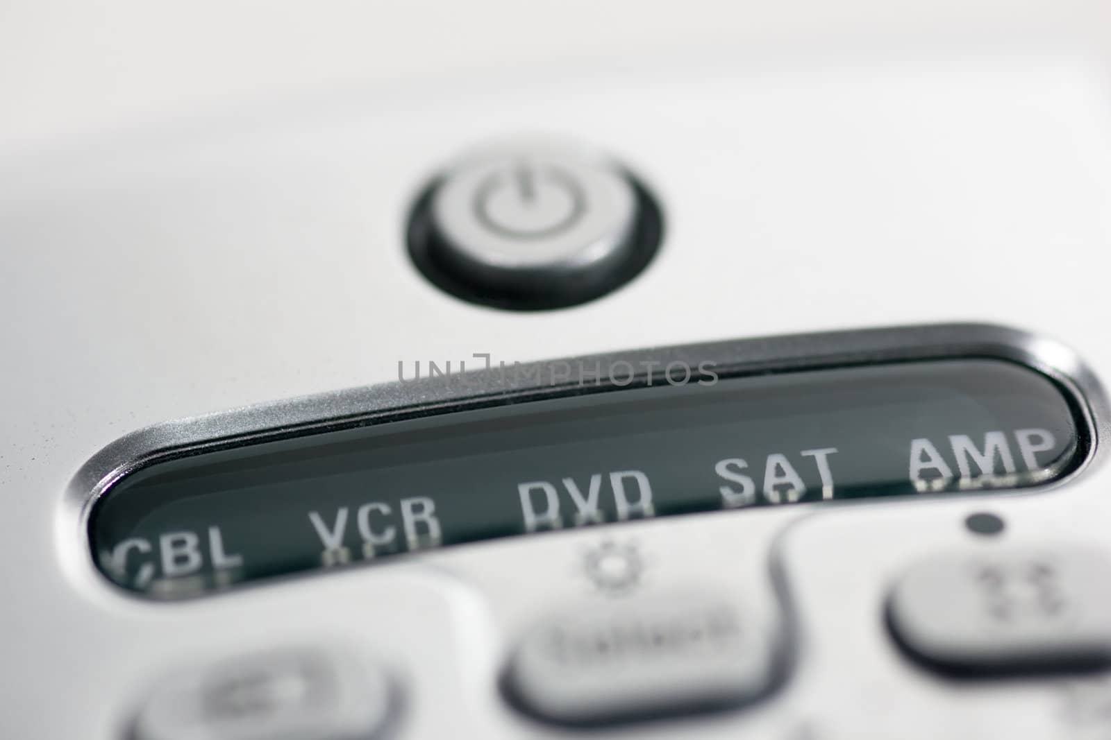 Closeup of a tv remote control, focus on the power button.