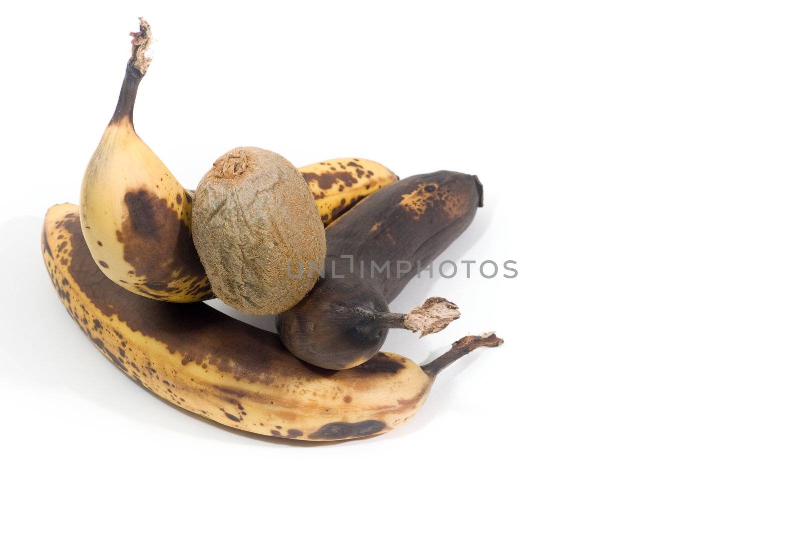 3 over-ripened bananas and a kiwi, isolated on white.