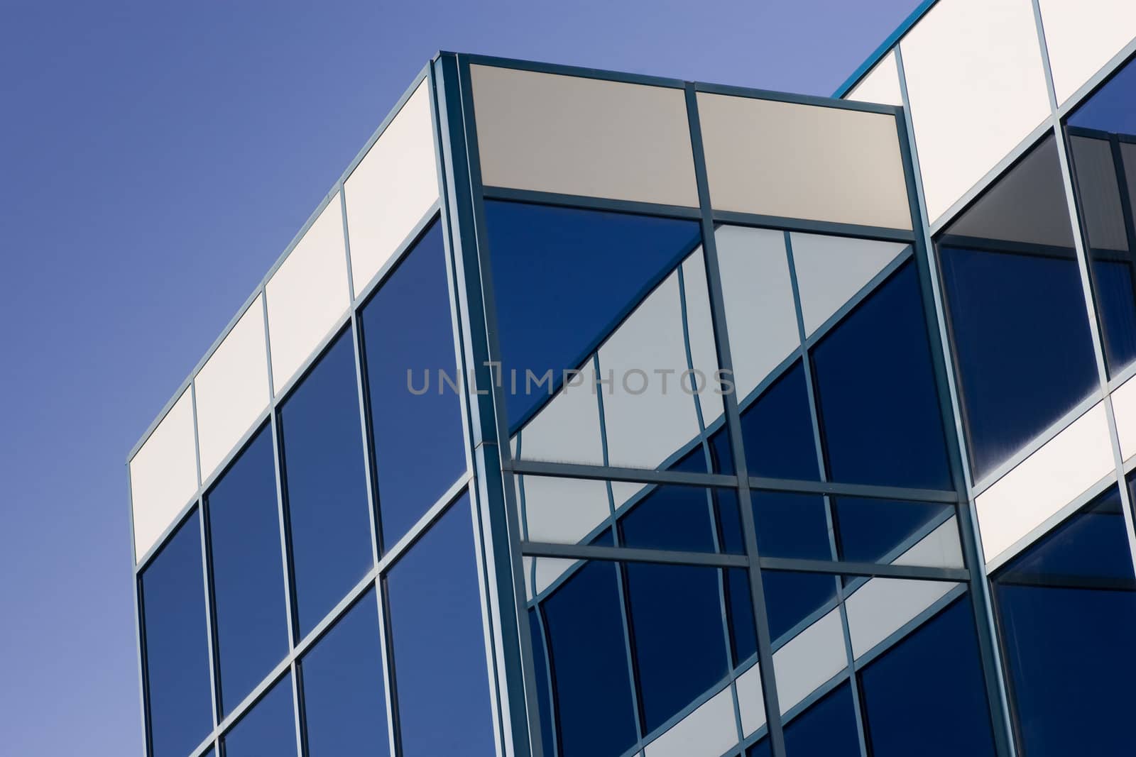 Glass Office Building and reflection, with a blue sky background.