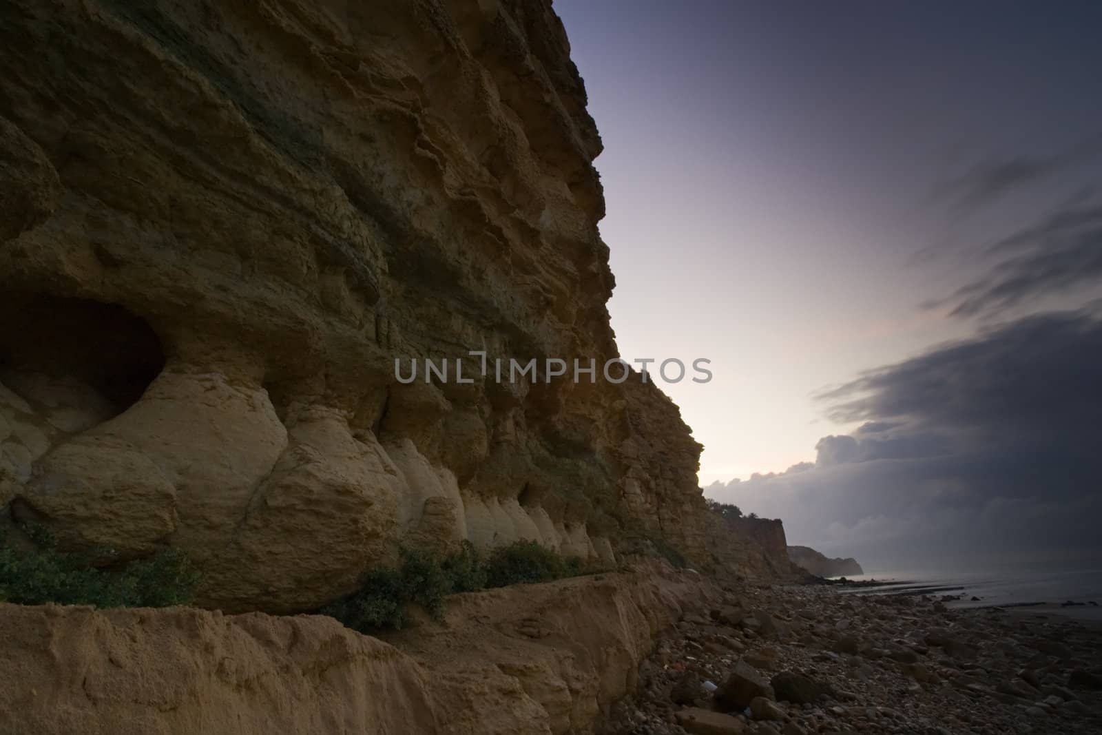 Cliff detail fading into an early morning sky, along the beaches in Lagos, Portugal.
