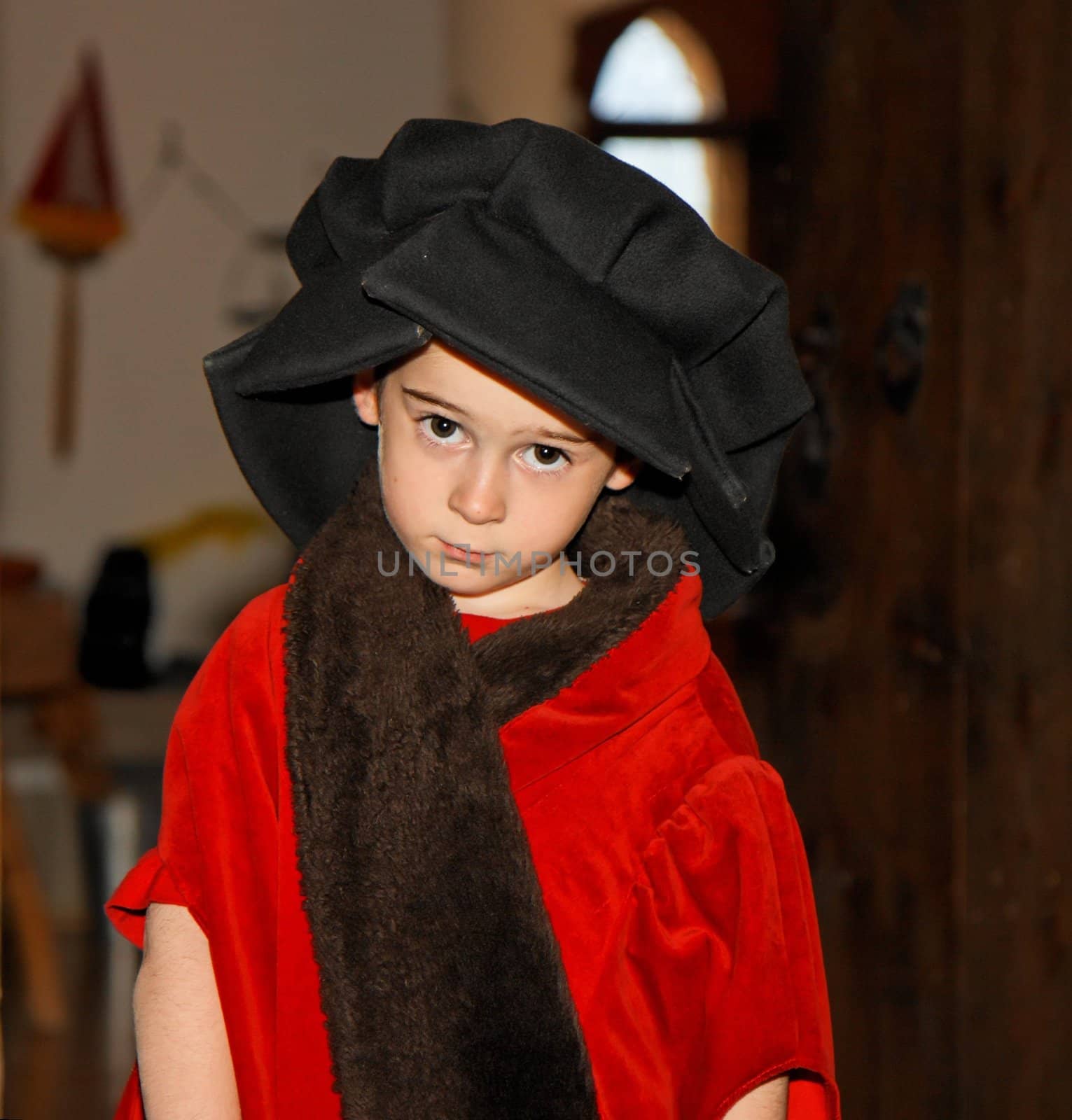 Serious cute little boy in medieval costume standing 