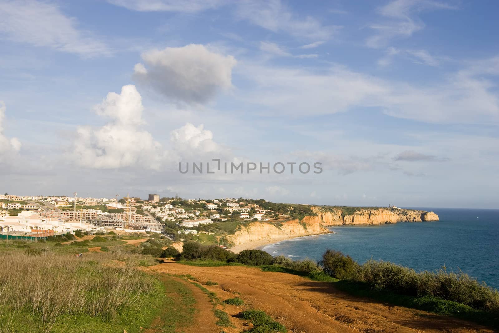 The town of Lagos in the Algarve, Portugal, shot from the clifftops, with the coastline also visible.