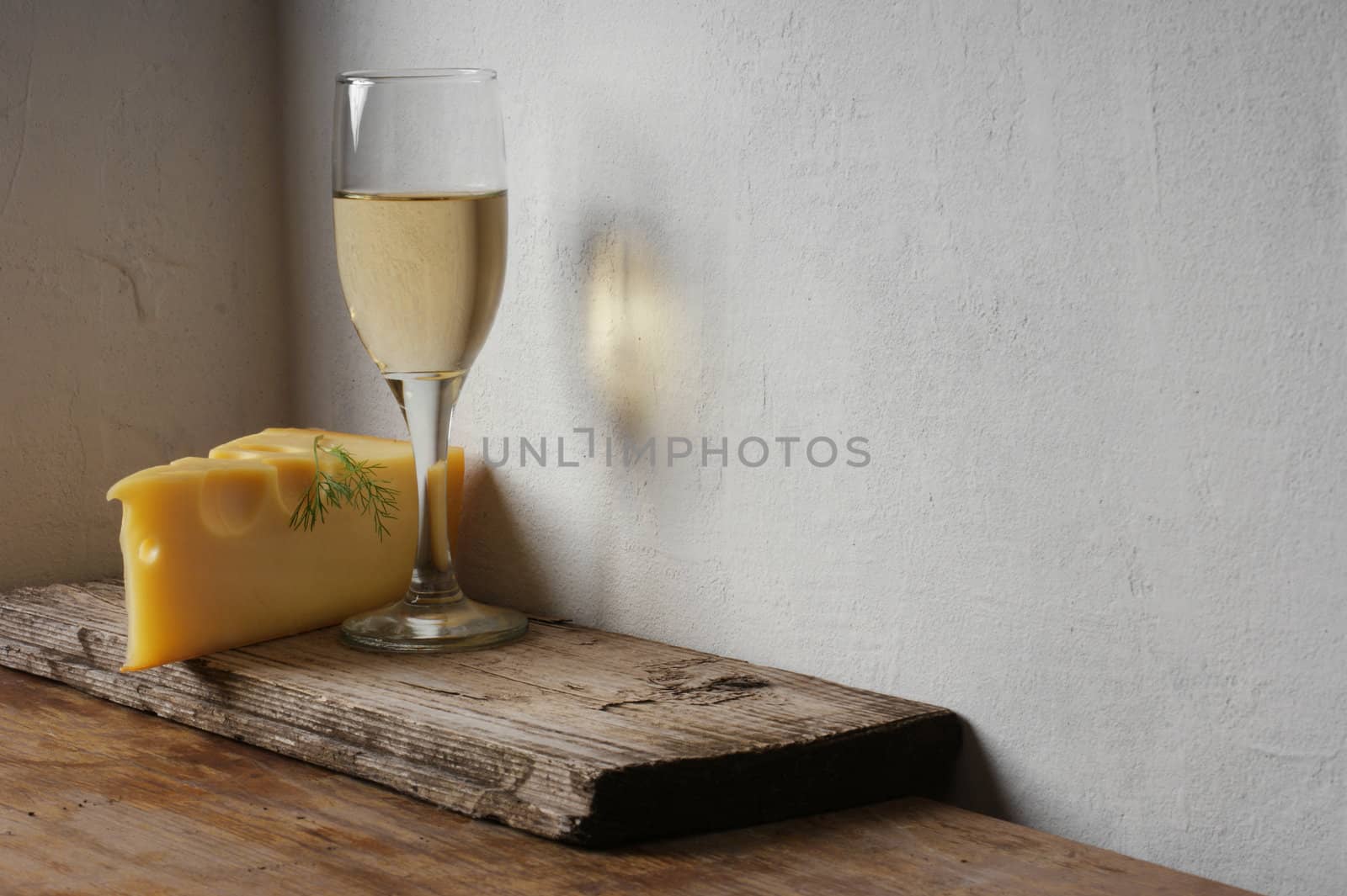 A glass of wine and cheese on the background wall