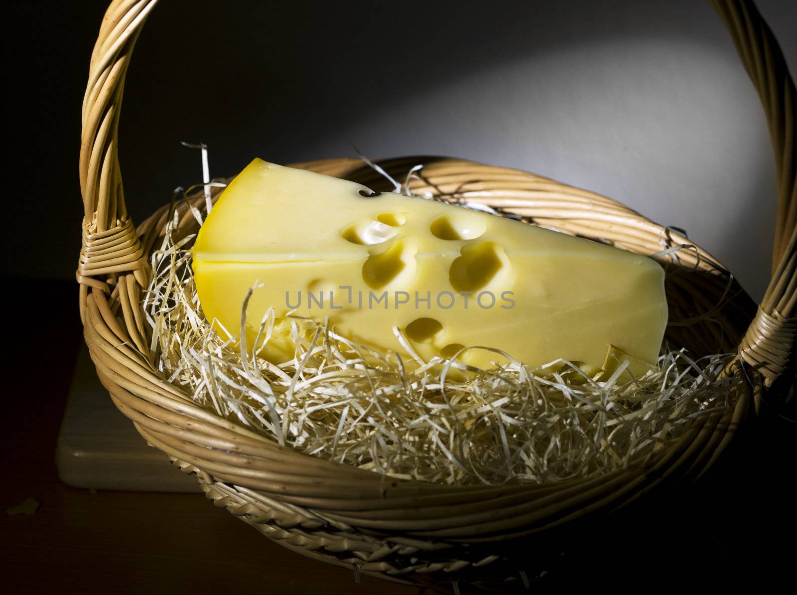 a piece of cheese in the basket ,still life