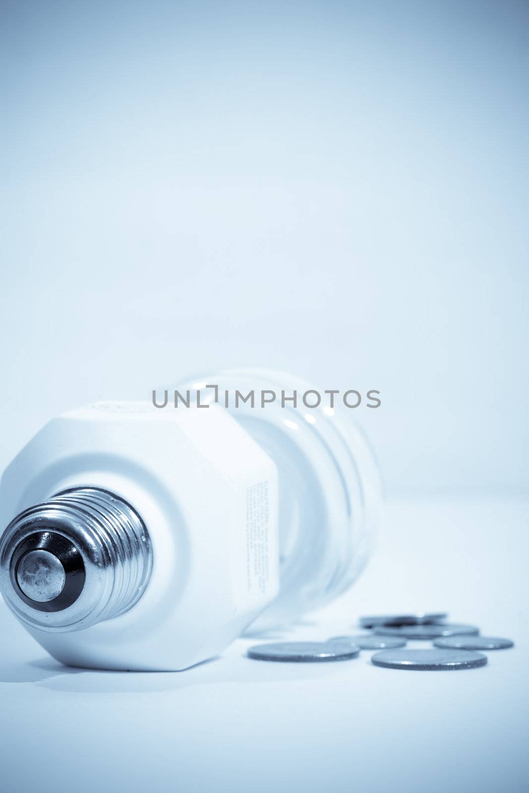 Compact fluorescent bulb with some change beside it.