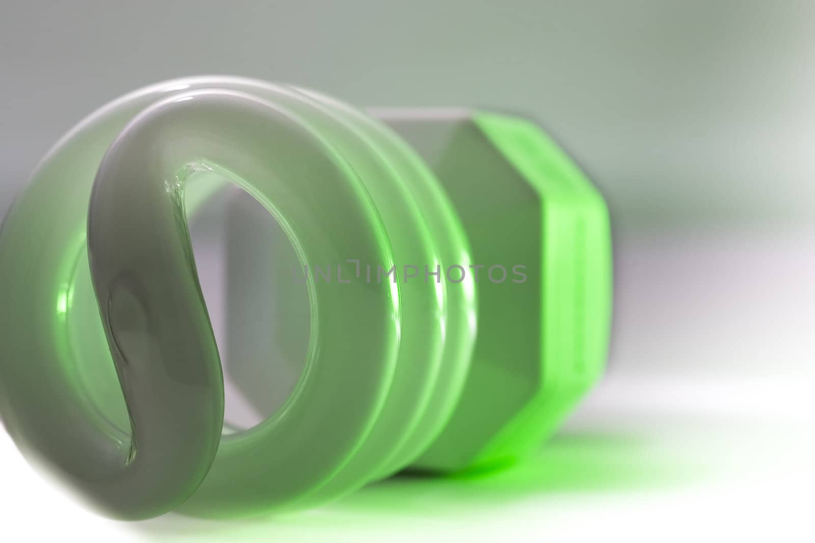 A green glowing compact fluorescent bulb.
