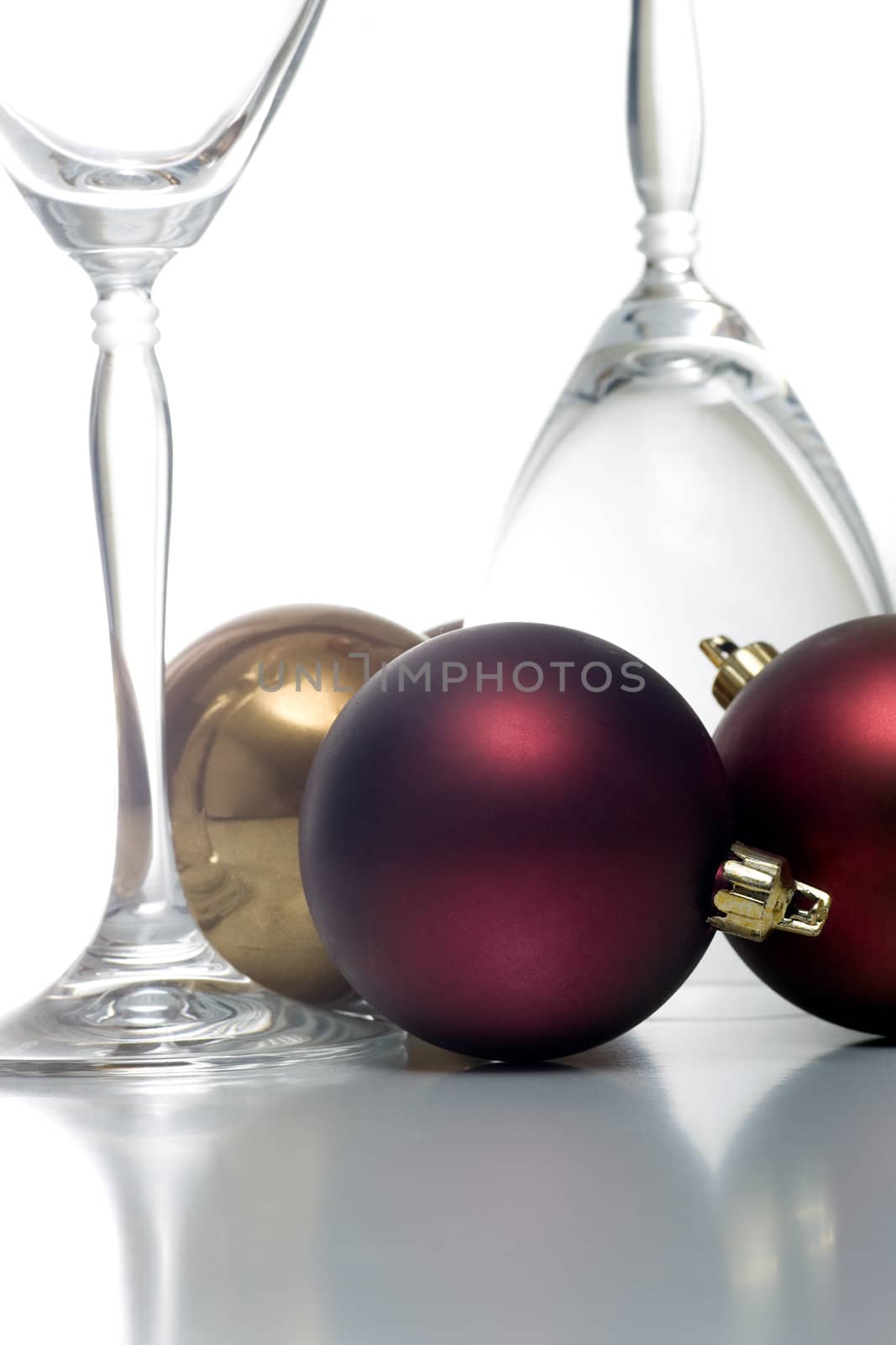 Champagne glasses surrounded by christmas ornaments, isolated on white.